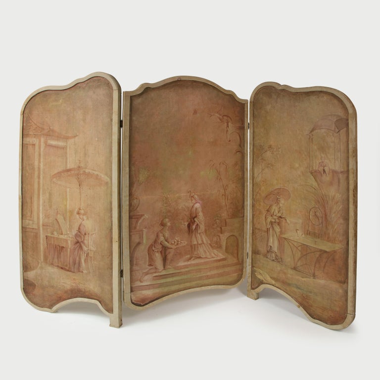 Comprising three shaped oil on canvas panels, with shirred ivory silk to the reverse, within a conforming greige-painted surround exquisitely painted in lavender sepia tones with scenes of Court figures pursuing leisurely activities in outdoor