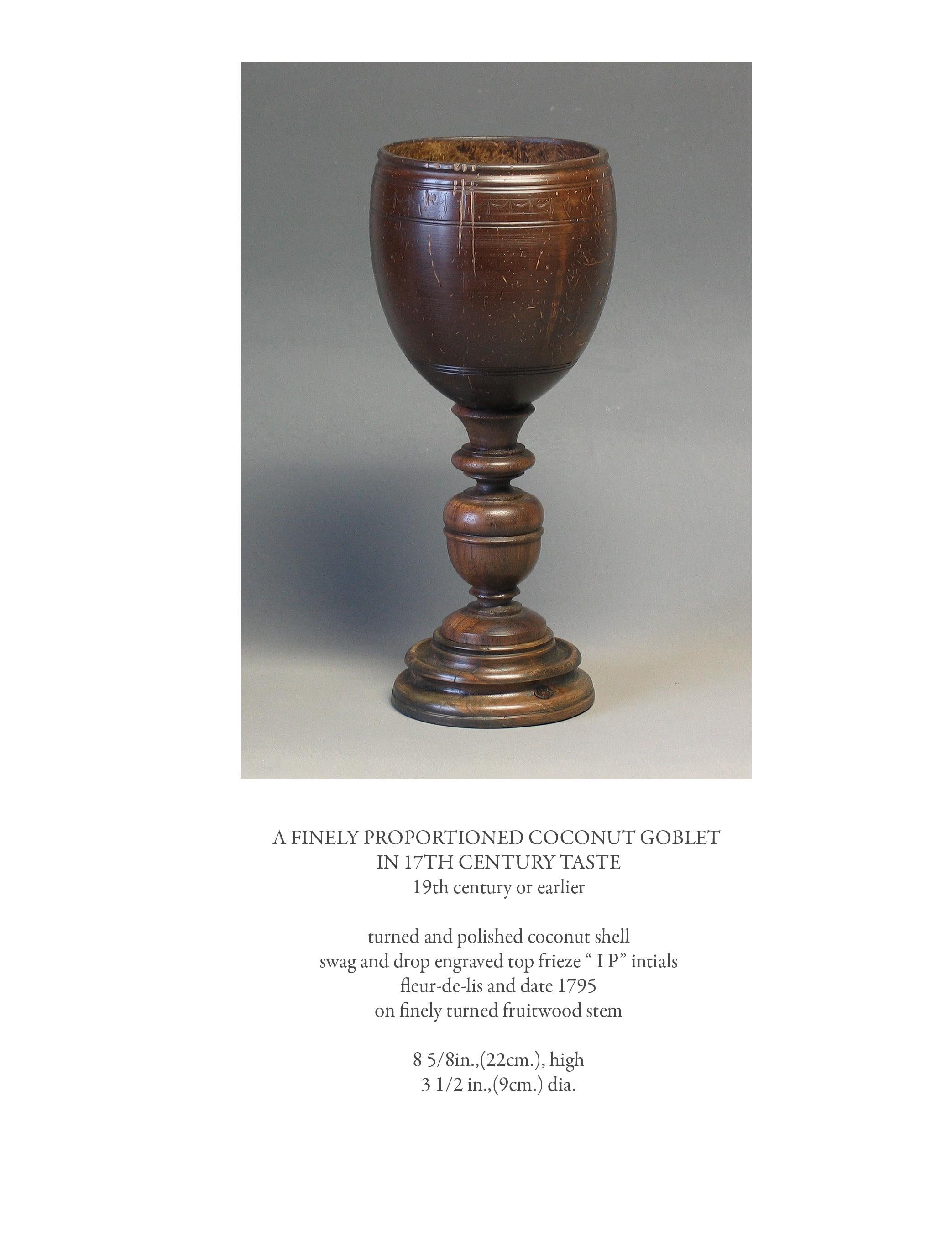 A finely proportioned coconut goblet in 17th century taste
19th century or earlier.

Turned and polished coconut shell,
swag and drop engraved top frieze, “ I P” intials,
fleur-de-lis and date 1795,
on finely turned fruitwood