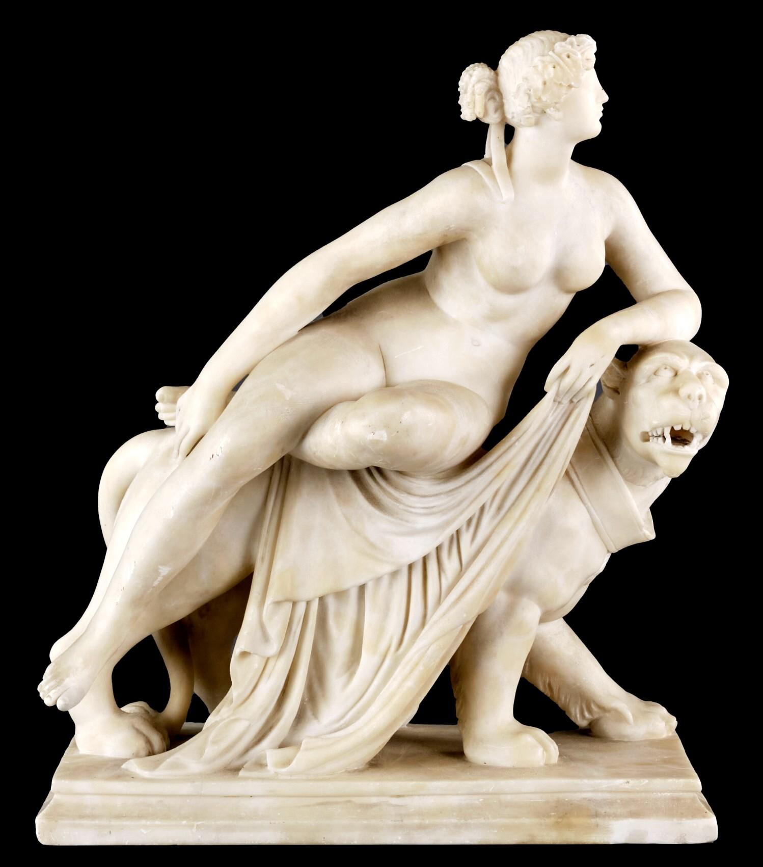 A large & finely sculpted alabaster figure of Ariadne, wife of Dionysus the God of wine, shown adorned with a diadem of vine leaves while in repose atop the back of Dionysus’s striding panther. 
Sensitively & skillfully carved with exacting
