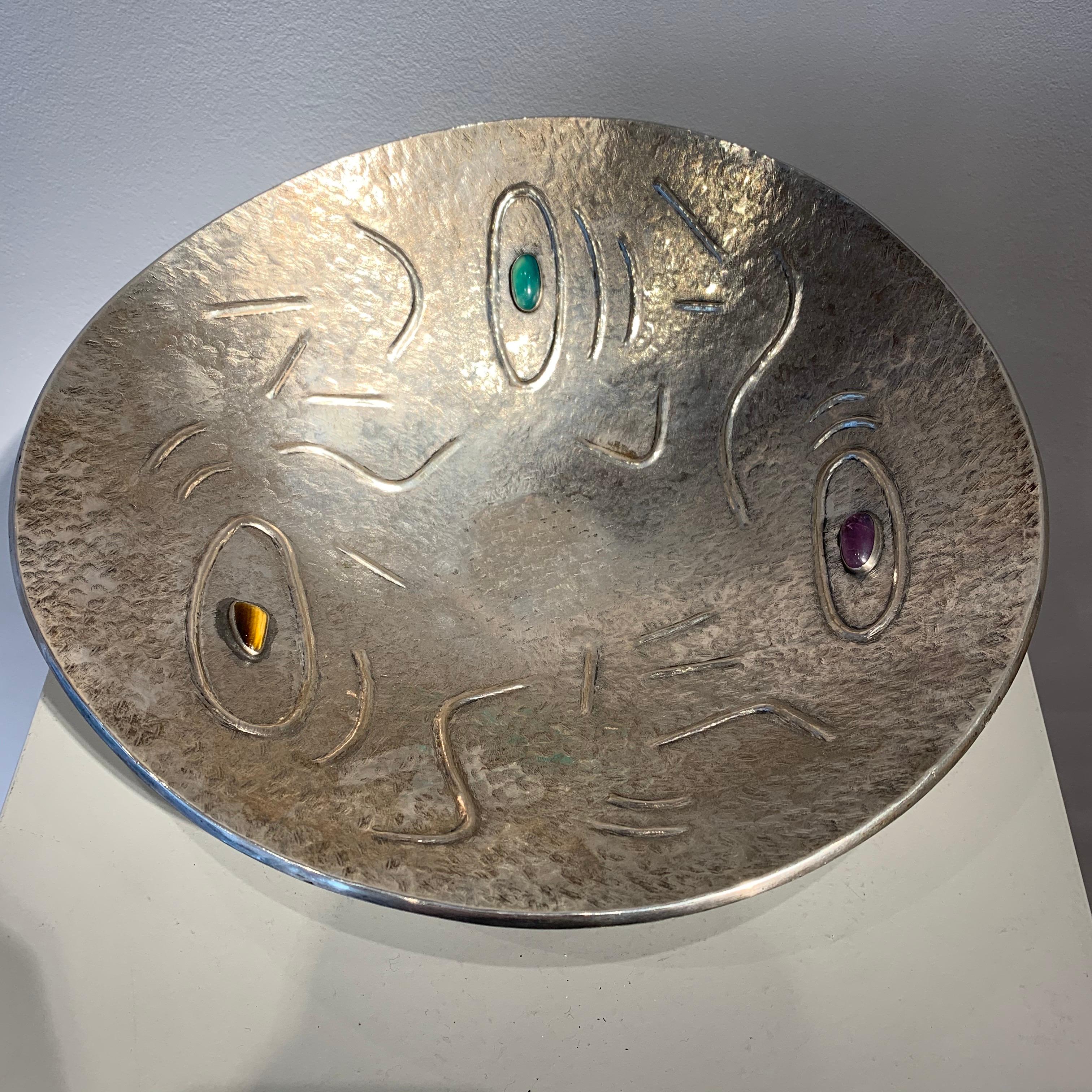 Finzi is a famous Italian Goldsmith. Typical of his work is silver objects with stones inserted. The design of this bowl shows an abstract decorative pattern.