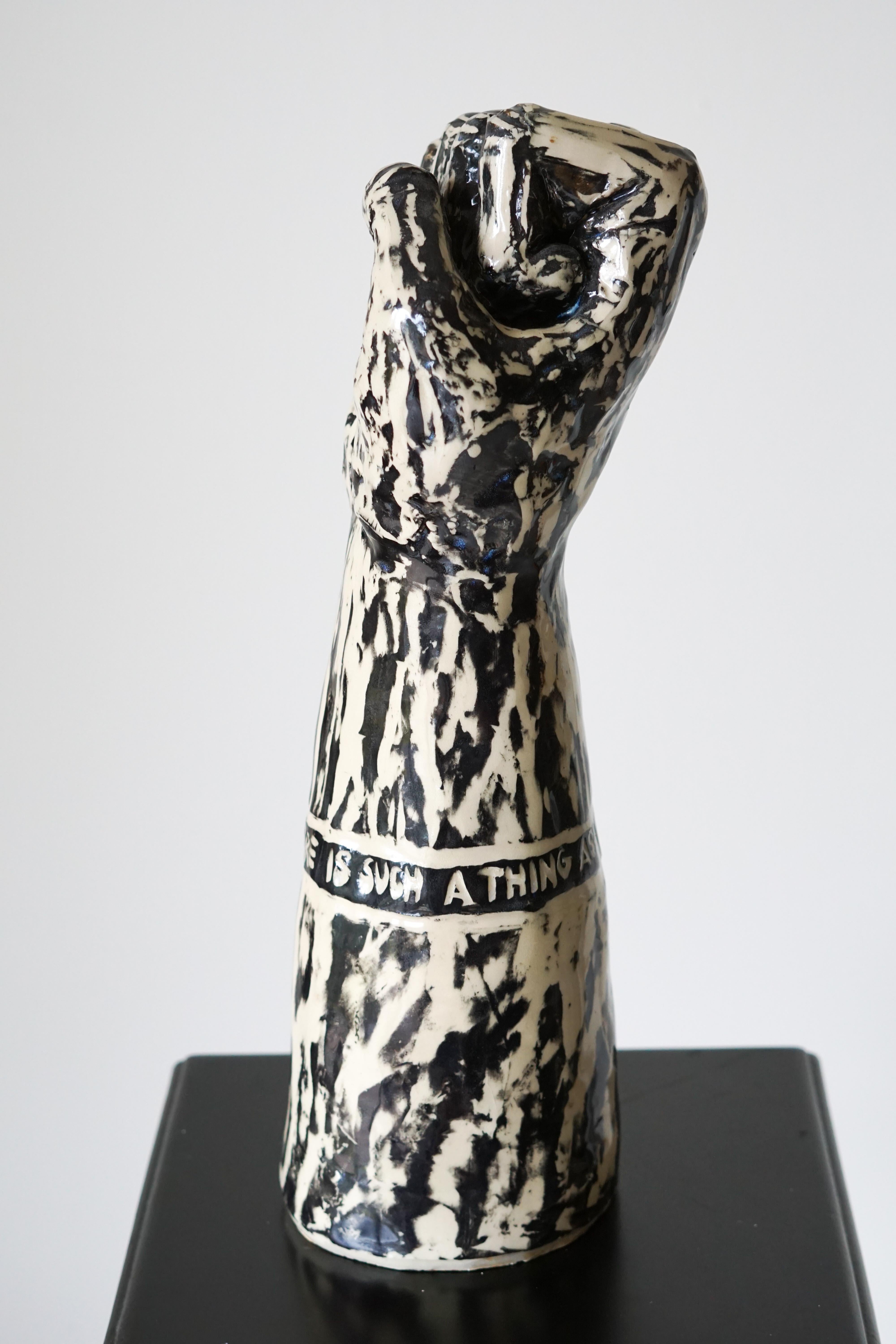 A fist is not a fight
Ceramic sculpture with under glaze Sgraffito


This sculpture features a white and black scraped surface with hints of blue glaze gathered in some crevices. The arm carries a quote around the form which reads,” There is