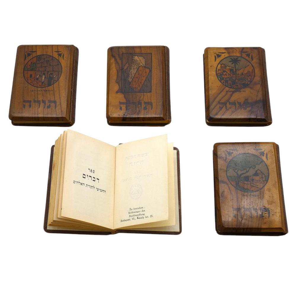 This exquisite five-volume miniature Bible set is a remarkable and rare artifact, handcrafted in pre-1948 Israel. Encased in beautifully hand-carved olivewood bindings, each volume reflects the deep spiritual and artistic traditions of the Holy