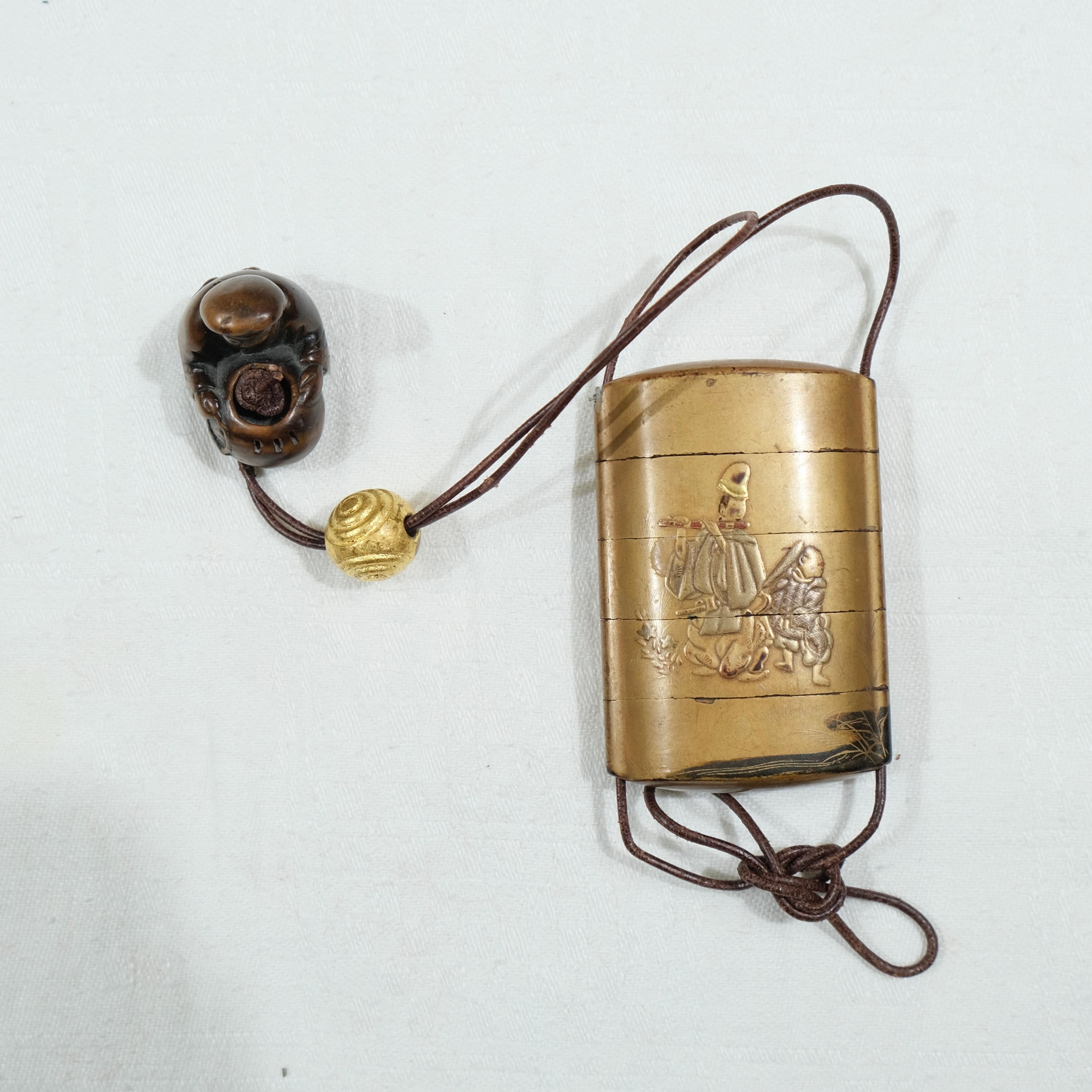 A nicely designed Japanese lacquer Inro with a wooden netsuke. The Inro with motives of a man playing a flute on one side and a creek on the other side. The Netsuke with signature.