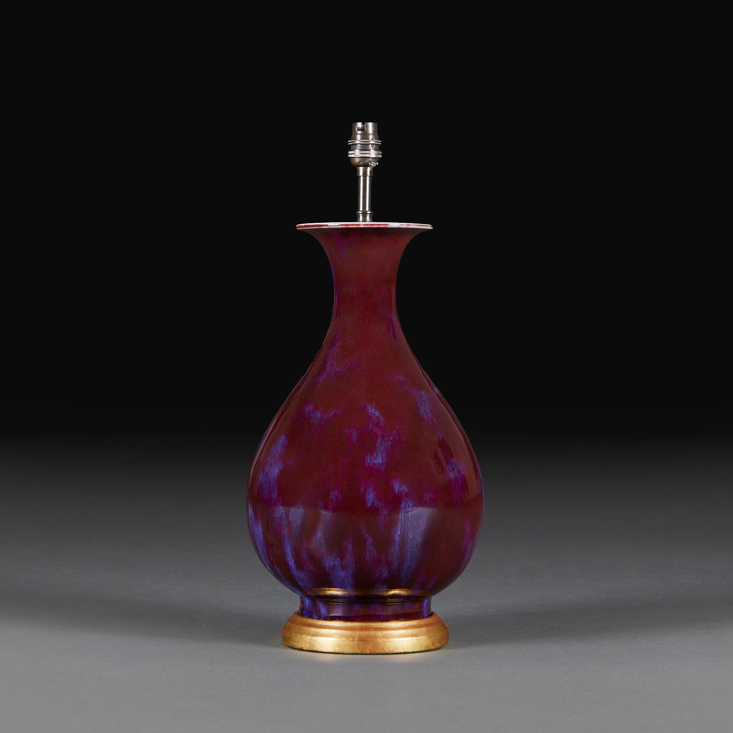 A late 19th century flambé vase of mei ping form now mounted as a lamp with a turned giltwood base.

Please note:

Lampshade not included. Lamp photographed with a 16” diameter pale cream card Pembroke lampshade.

Currently wired for the UK with