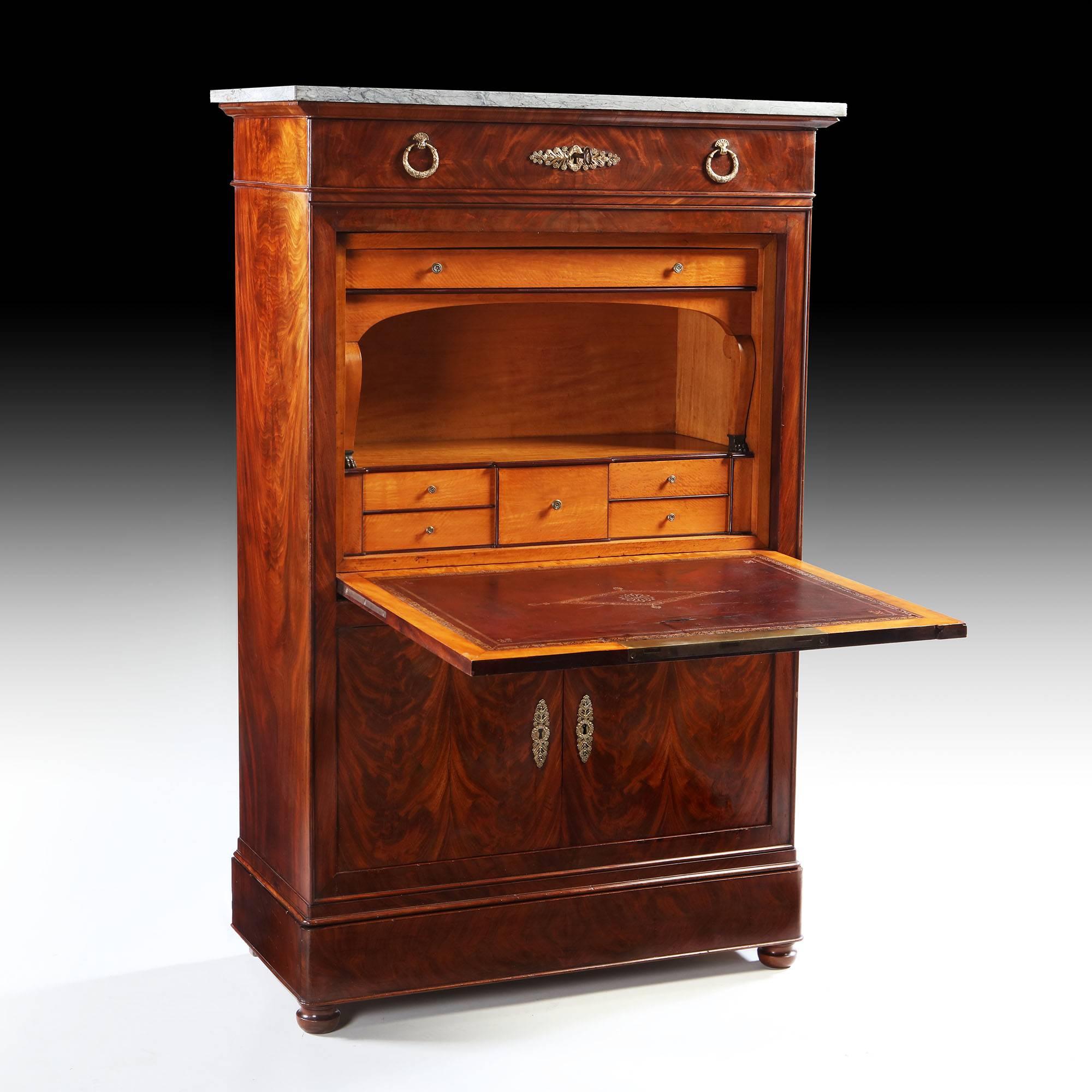 A fine early 19th century flame mahogany secretaire a abattant with ormolu mounts, the upper body with satinwood interior, original red leather and gilt tooled writing surface, and a drawer to the frieze, all surmounted by original veined marble