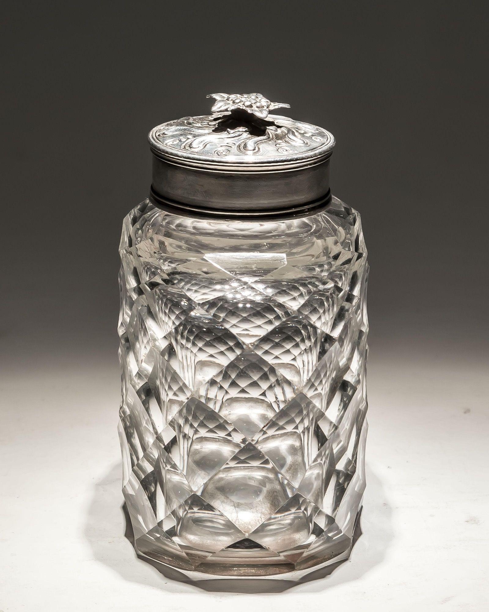 A flat diamond cut tea caddy with silver mount and decorated cap.