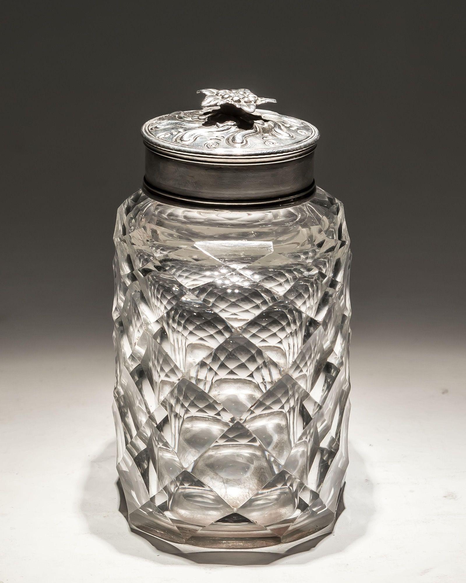 Eine flache Teedose im Diamantschliff mit Silbermontierung und verzierter Kappe.