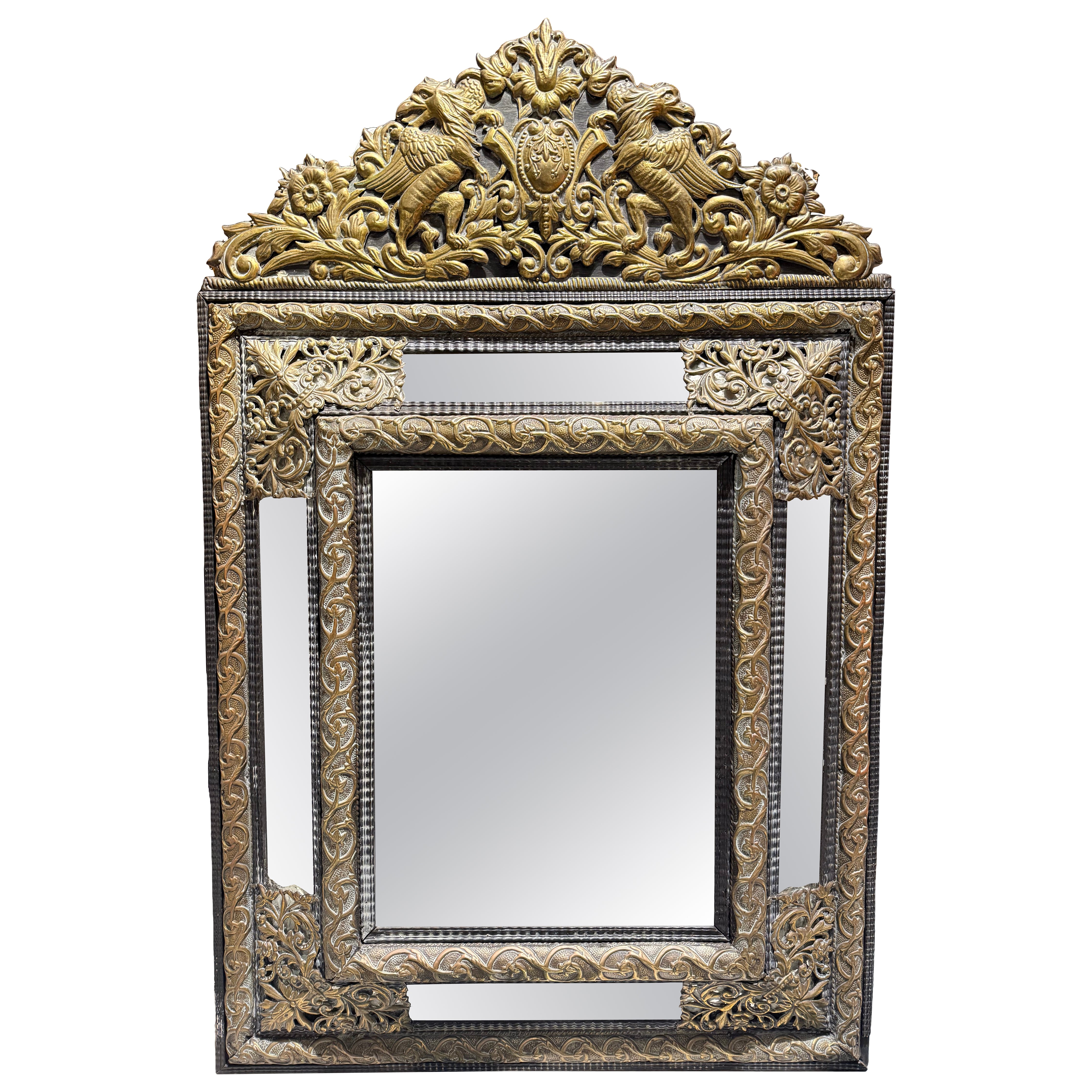 A Flemish Embossed Brass and Ebonised Cushion Fronted Mirror, 19th Century