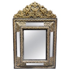 A Flemish Embossed Brass and Ebonised Cushion Fronted Mirror, 19th Century