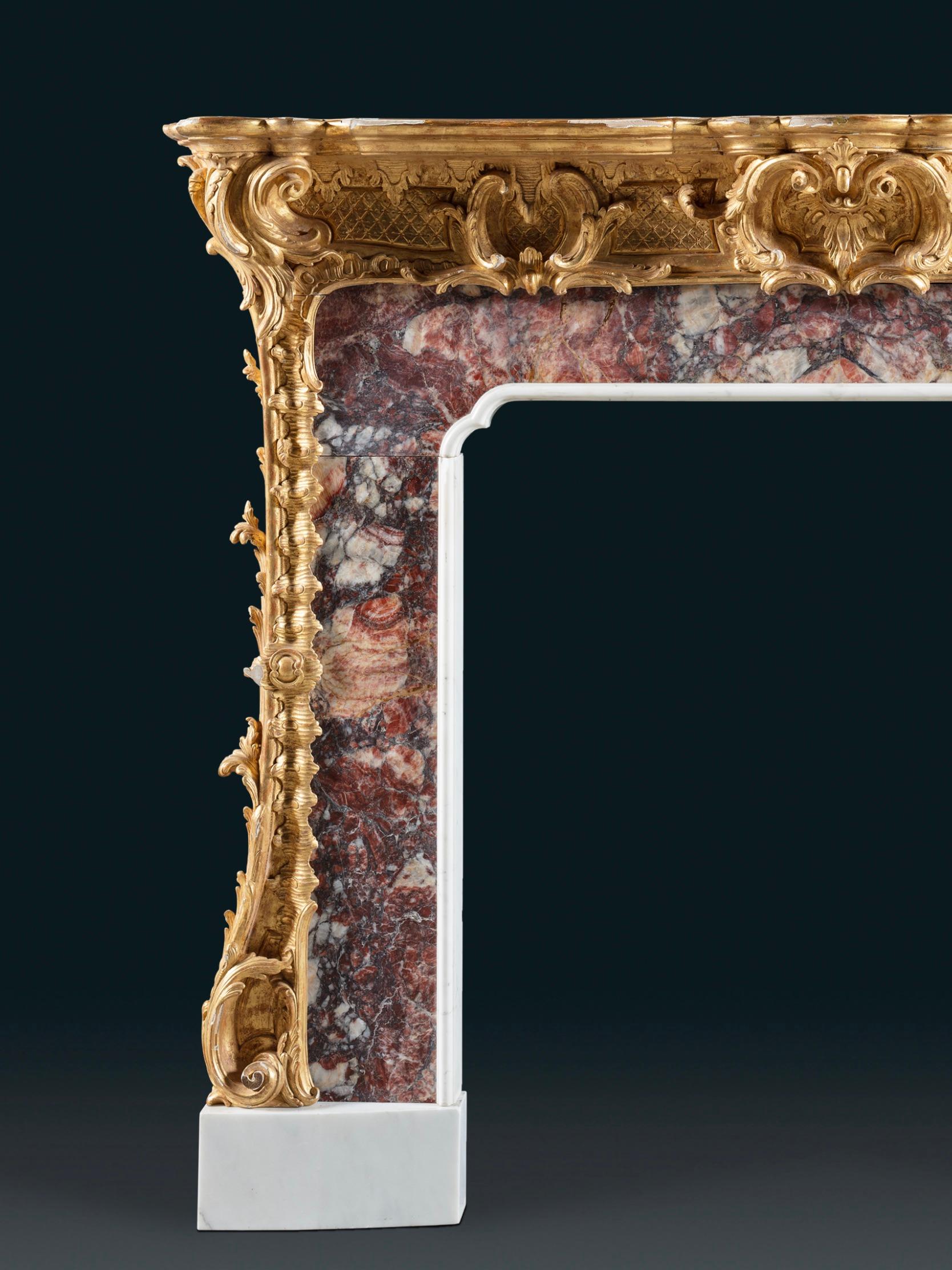 Ein geschnitzter Kamin aus Goldholz und Marmor im Stil von Thomas Johnson (1714-1778), einem englischen Designer und Meisterschnitzer. Die originale vergoldete Oberfläche des geschnitzten Rahmens mit Blattranken, Rauten und einem geritzten Grund