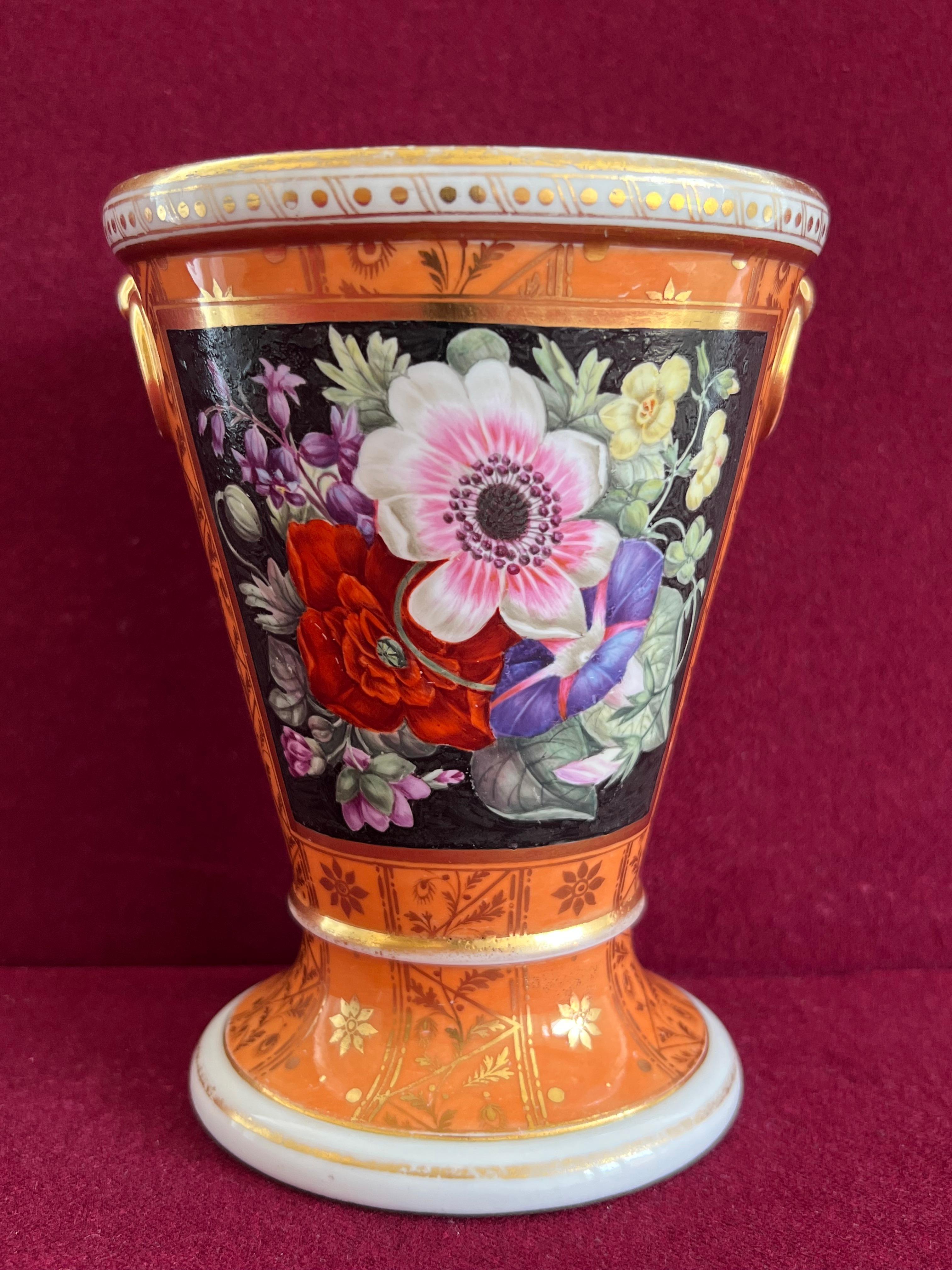 A flight and barr Worcester porcelain Jardiniere c.18001-1805 of flared tapering form, with fixed stand, two fixed gilt ring handles, painted with a panel of garden flowers on a black ground and gilded patterns on a salmon ground. Incised B mark to