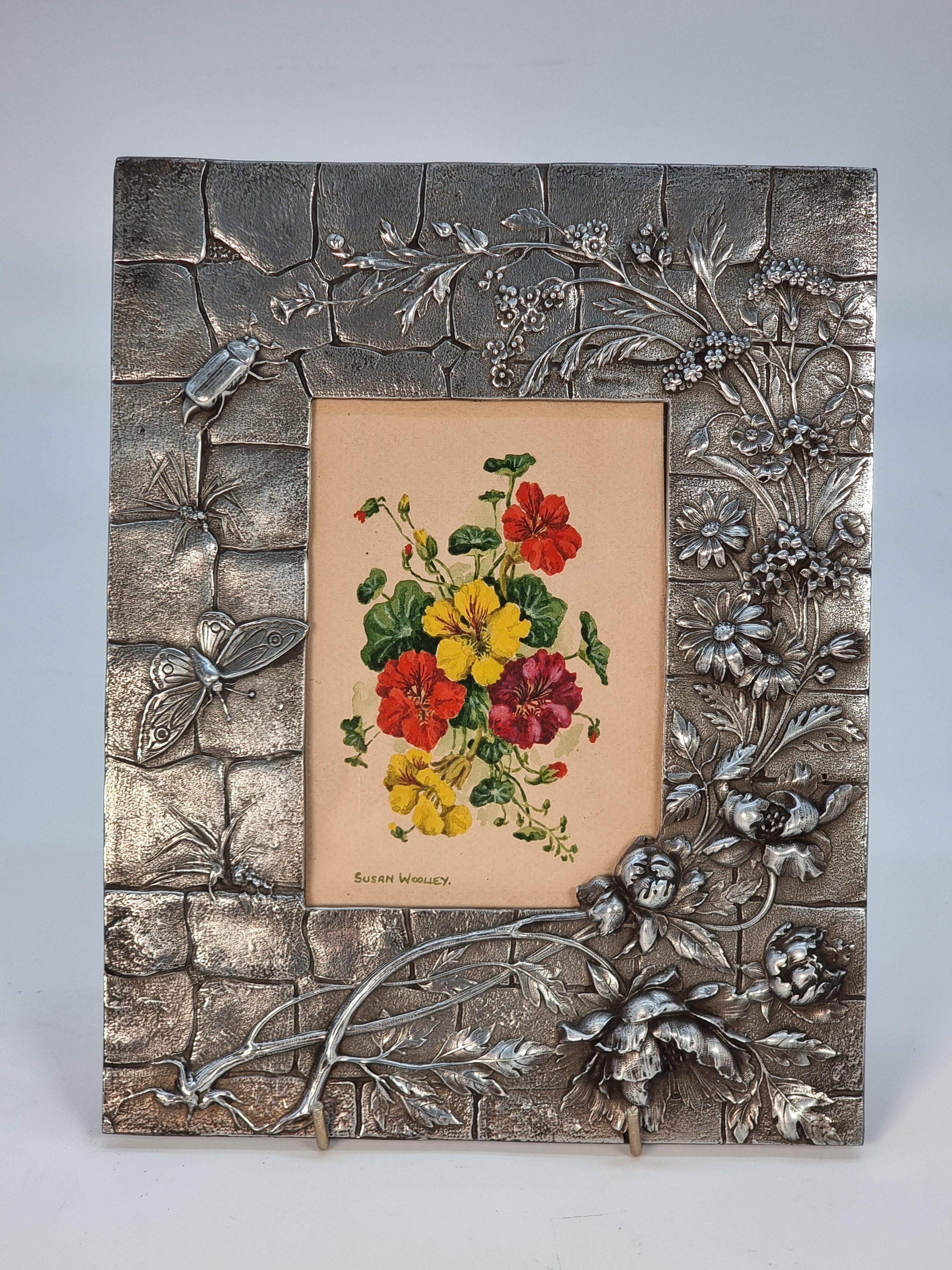This fine watercolour is a still life study of colourful flowering nasturtiums. It is displayed in a most unusual Aesthetic movement heavy cast deep relief pewter frame decorated with assorted flowers and insects.

This decorative polished pewter