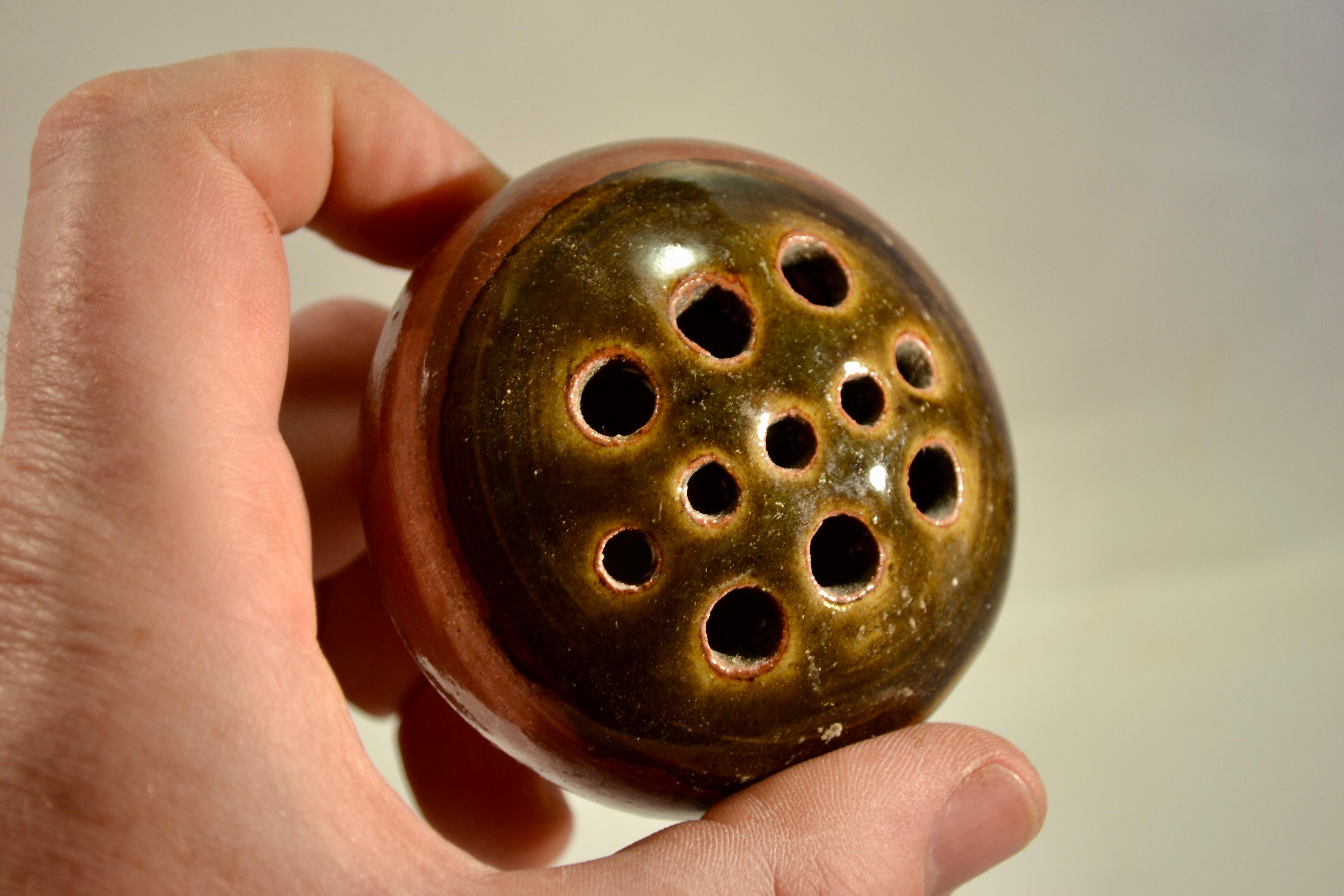 A flower pick holder made of pyrite-bearing stoneware in the shape of a sphere. French work from La Borne in the 1970s, featuring exquisite enamel.
