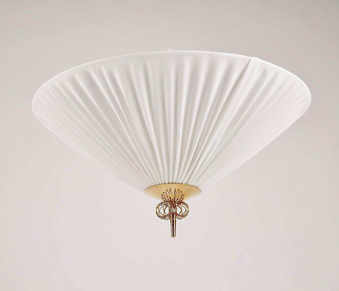 A flush mount lighting designed by Paavo Tynell, produced by Idman, model K5-26. Finland , Circa 1950th.
Pleated fabric shade with brass decor. (3) sockets. Existing wires, rewiring available upon request.
Diam 24 ; H 10″.