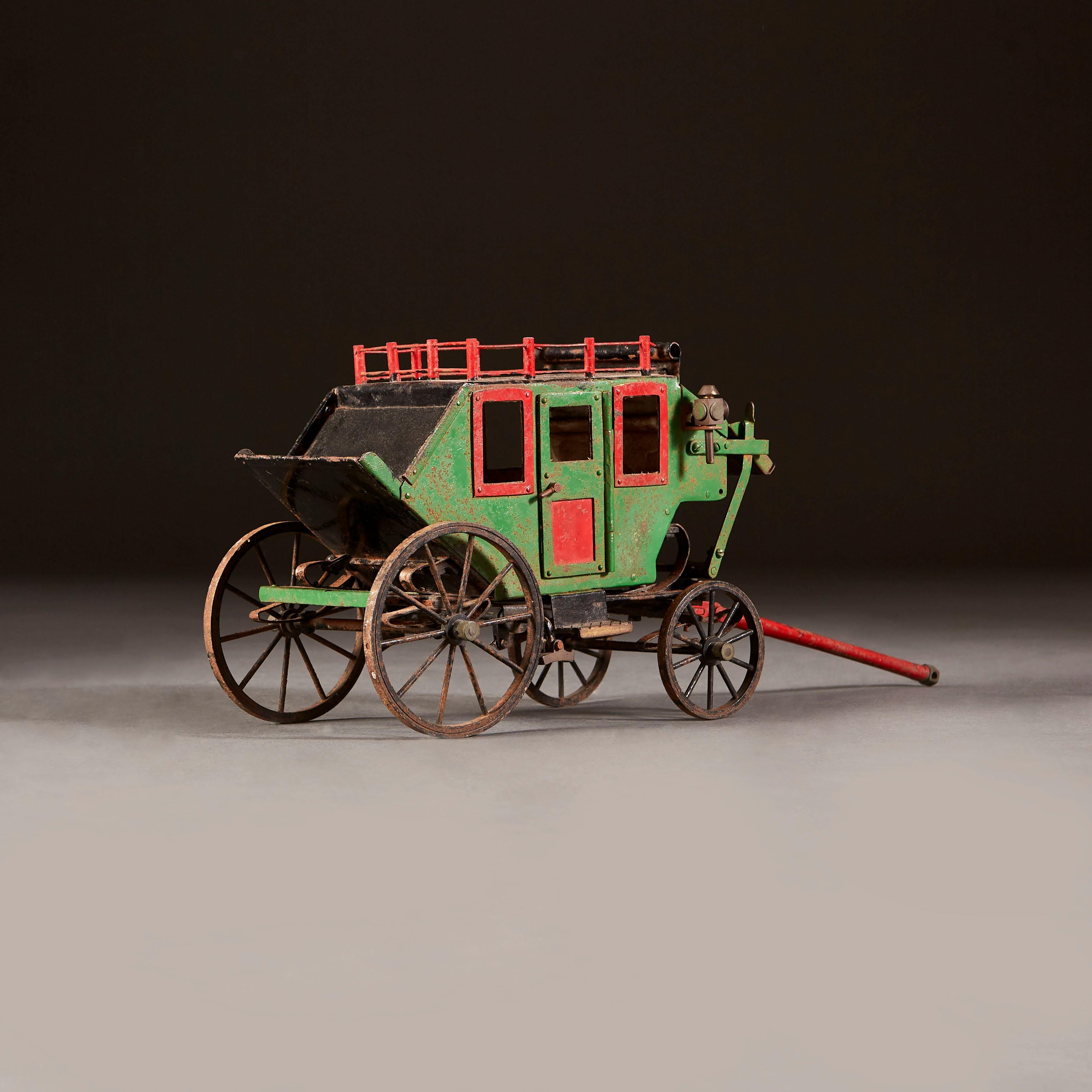 An early twentieth century folk art model of an American stage coach, with red balustrading and door frame and panels, the body painted in green. With tethering rod.