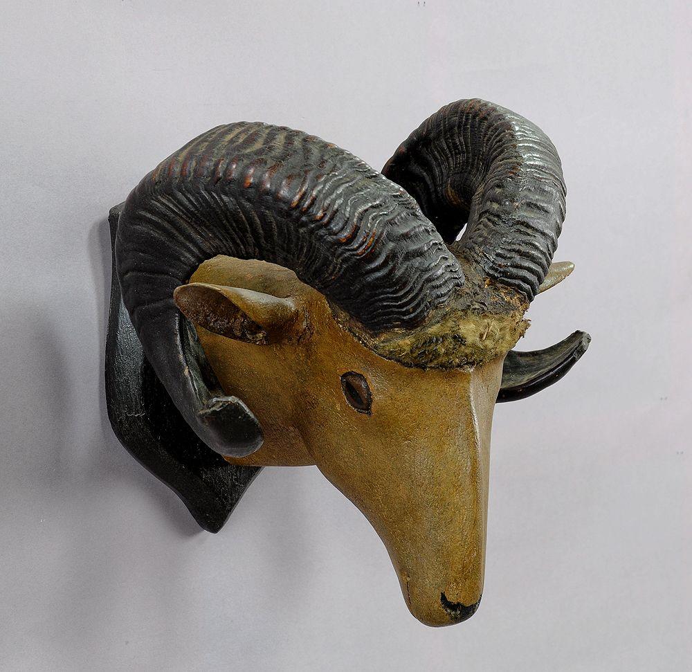 A folksy hand carved black forest ram head with original horns, mounted on a carved wood plaque. Executed in Germany, circa 1900.

Measures: Width 12.2