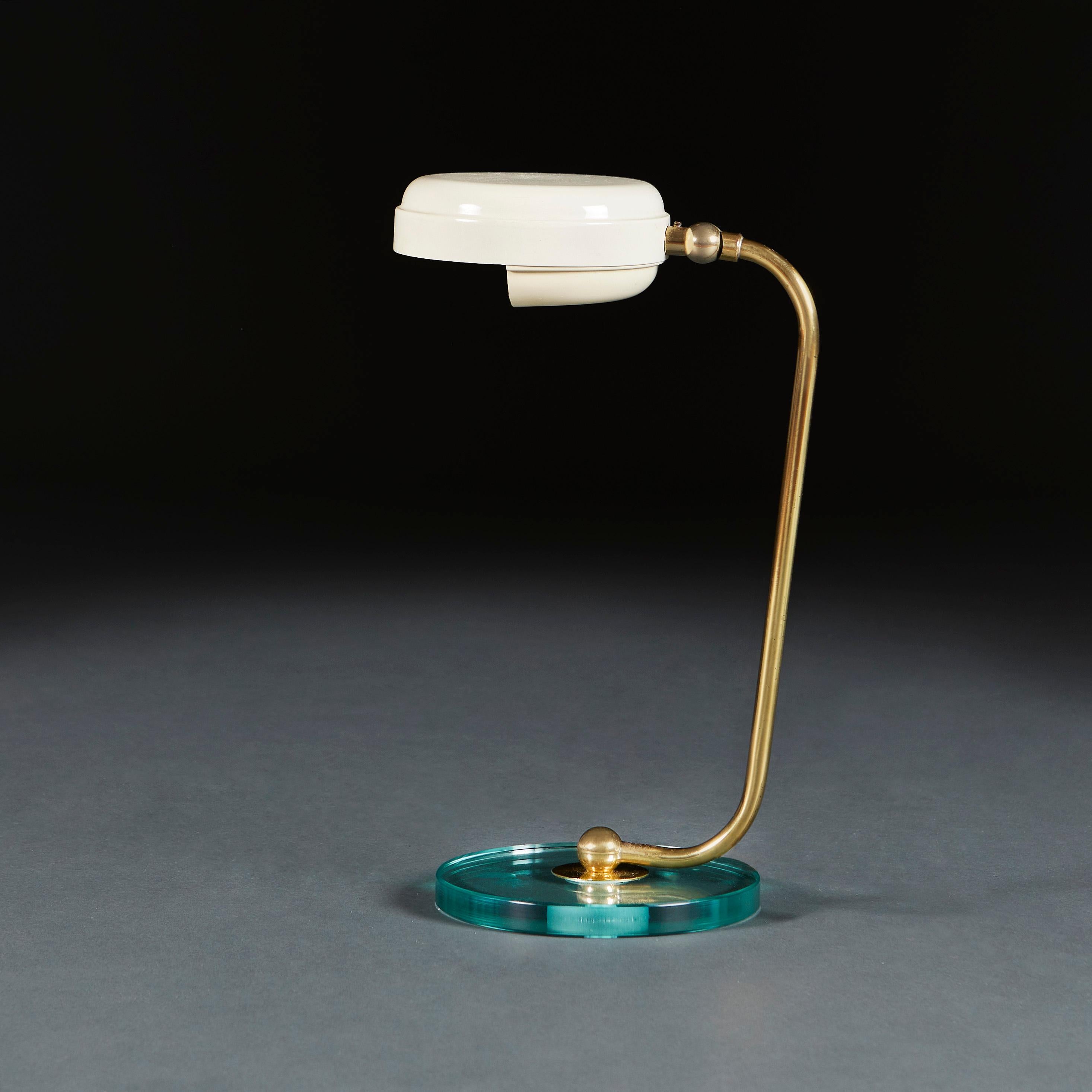 Italy, circa 1950

A mid 20th century desk lamp with circular glass base, curved brass stem, and articualted cream enamel disc form shade. Attributed to Fontana Arte.

Height 33.00cm
Width 15.00cm
Depth 20.00cm

Please note: This is currently wired