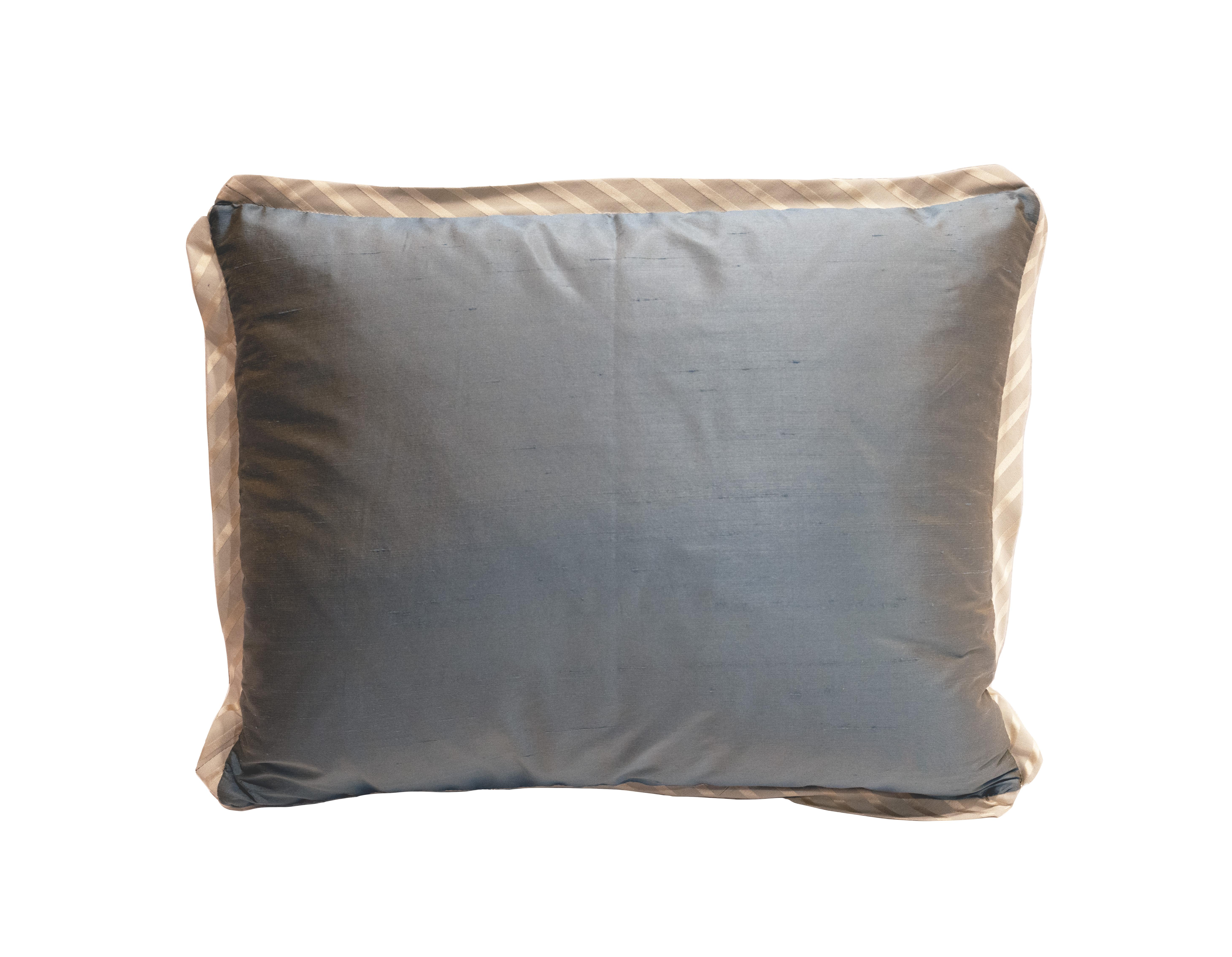 Coussin Fortuny à une seule pièce et à onglet dans le motif Ashanti en bleu ardoise et or argenté. Bordure en biais de soie rayée et dos en pongé de soie.