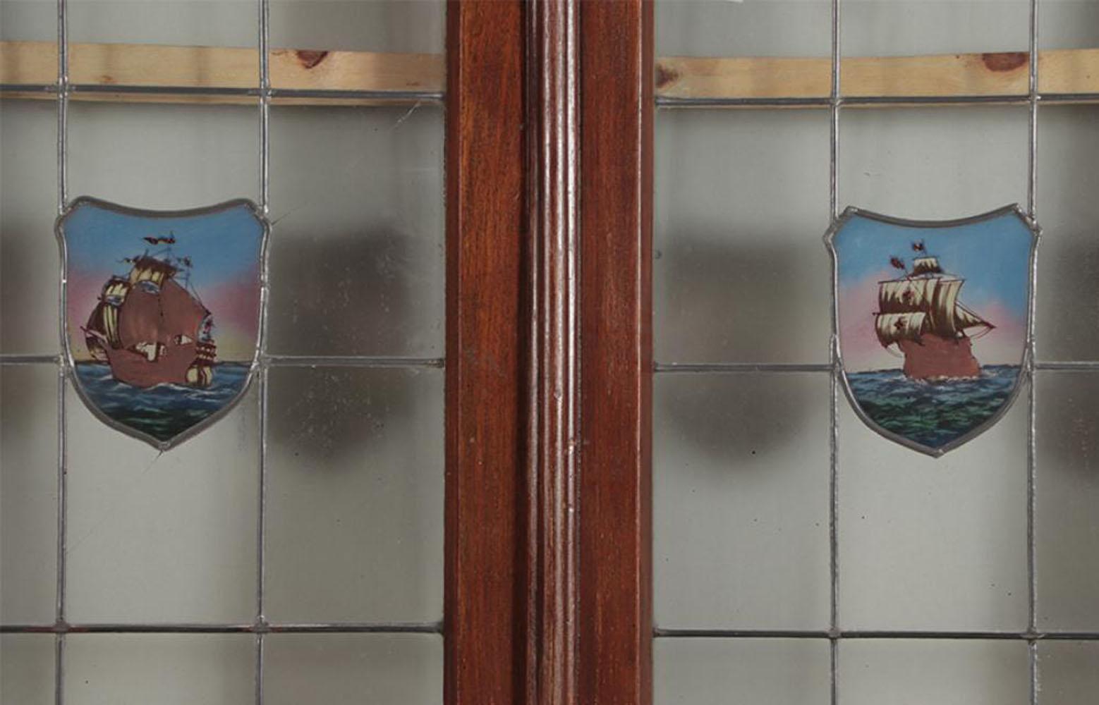 Ventana de caoba de cuatro hojas con marco y cristal emplomado, hacia 1920. Los cristales centrales tienen motivos navales. Estas ventanas de temática marítima serían un maravilloso complemento arquitectónico para un estudio, una despensa u otra