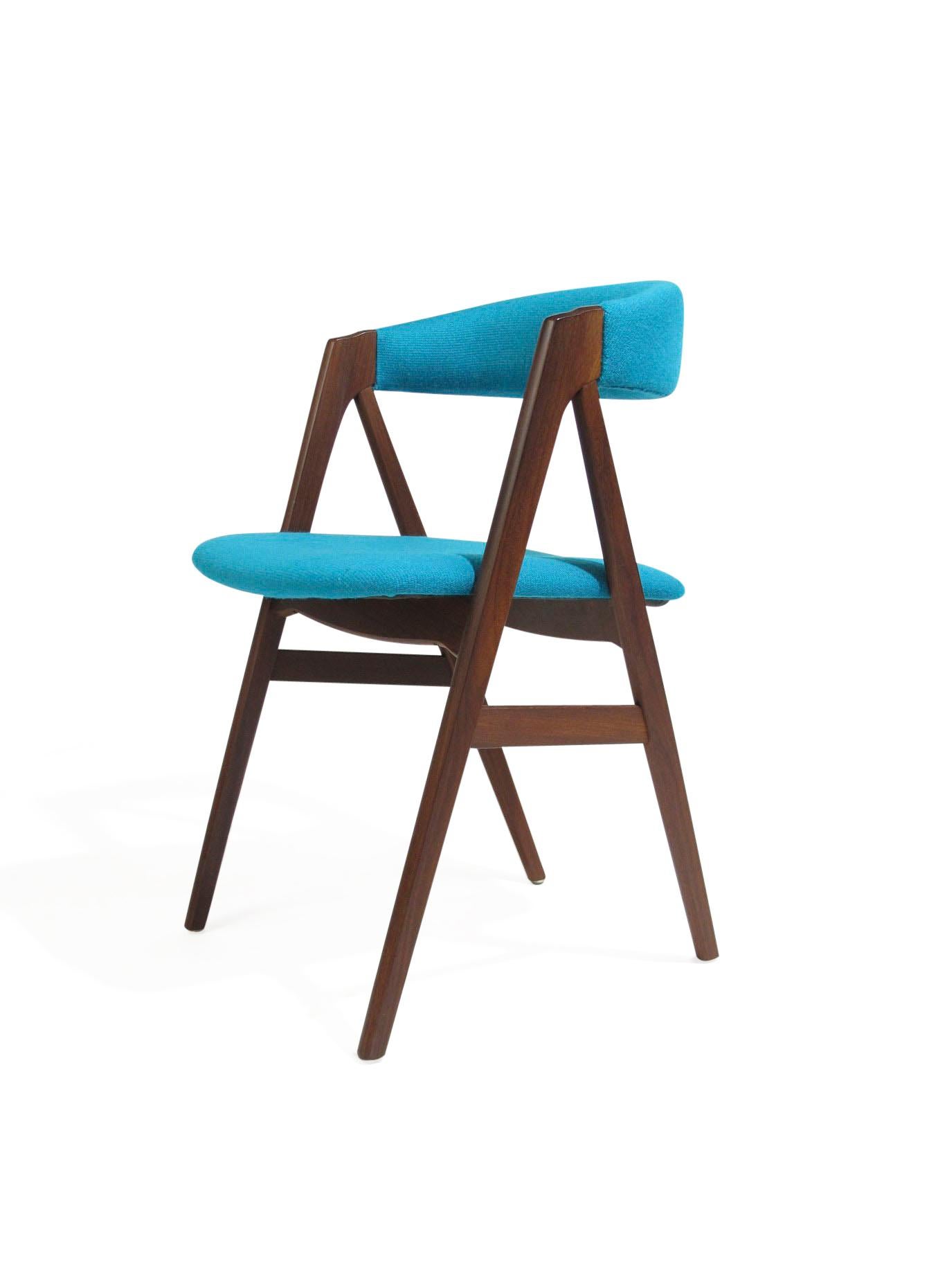Four midcentury dark teak dining chairs with comfortable curved backrest on a sturdy teak A-frame. Newly upholstered in a high-quality turquoise aqua blue wool textile over new foam. The wood has been professionally restored and in excellent