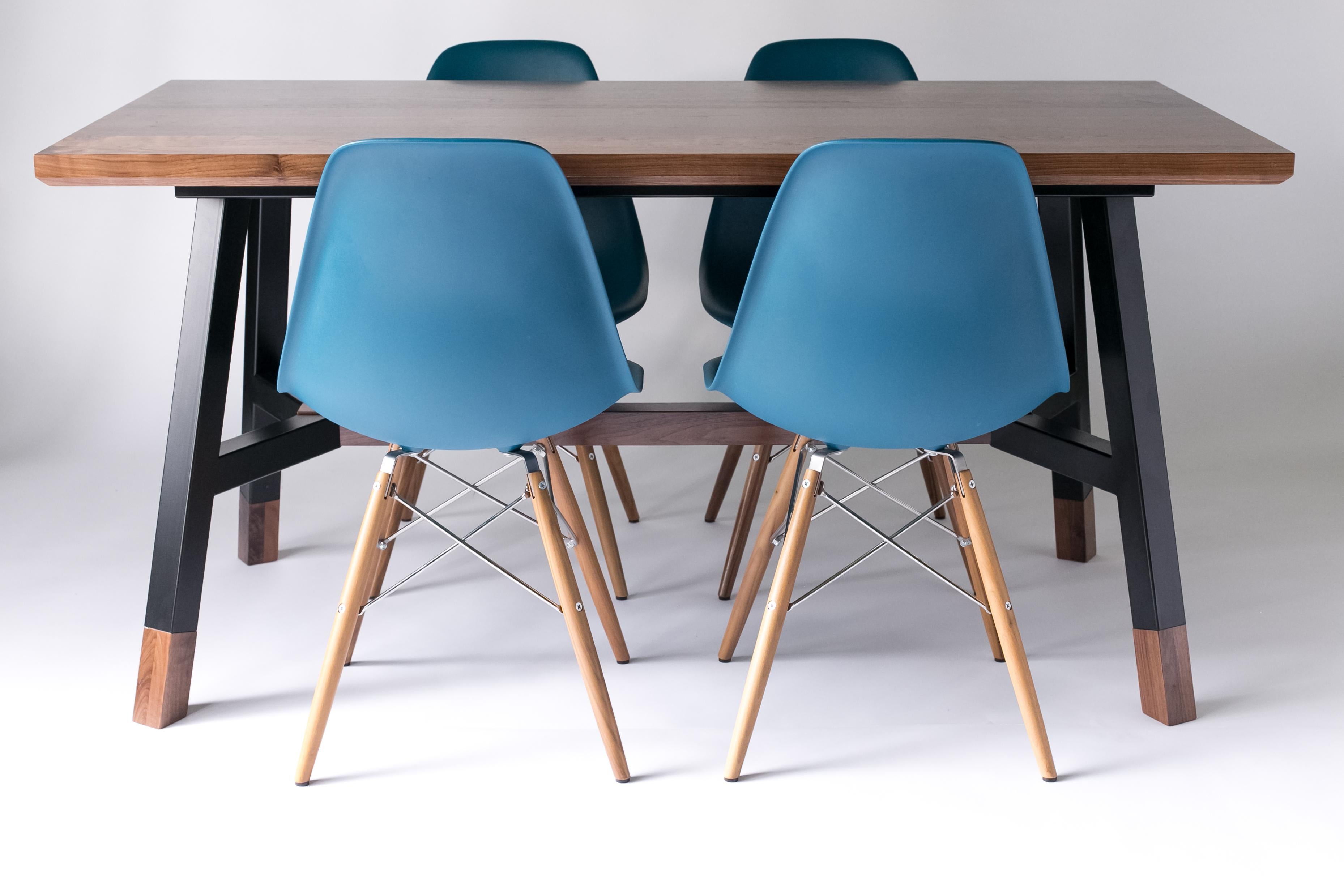 The A-Frame, modern walnut and powder coated steel dining table. 

Solid walnut table top with a chamfered edge. Powder coated welded steel base with solid hand-carved walnut feet and crossbar. Available in either black or white powder coating.