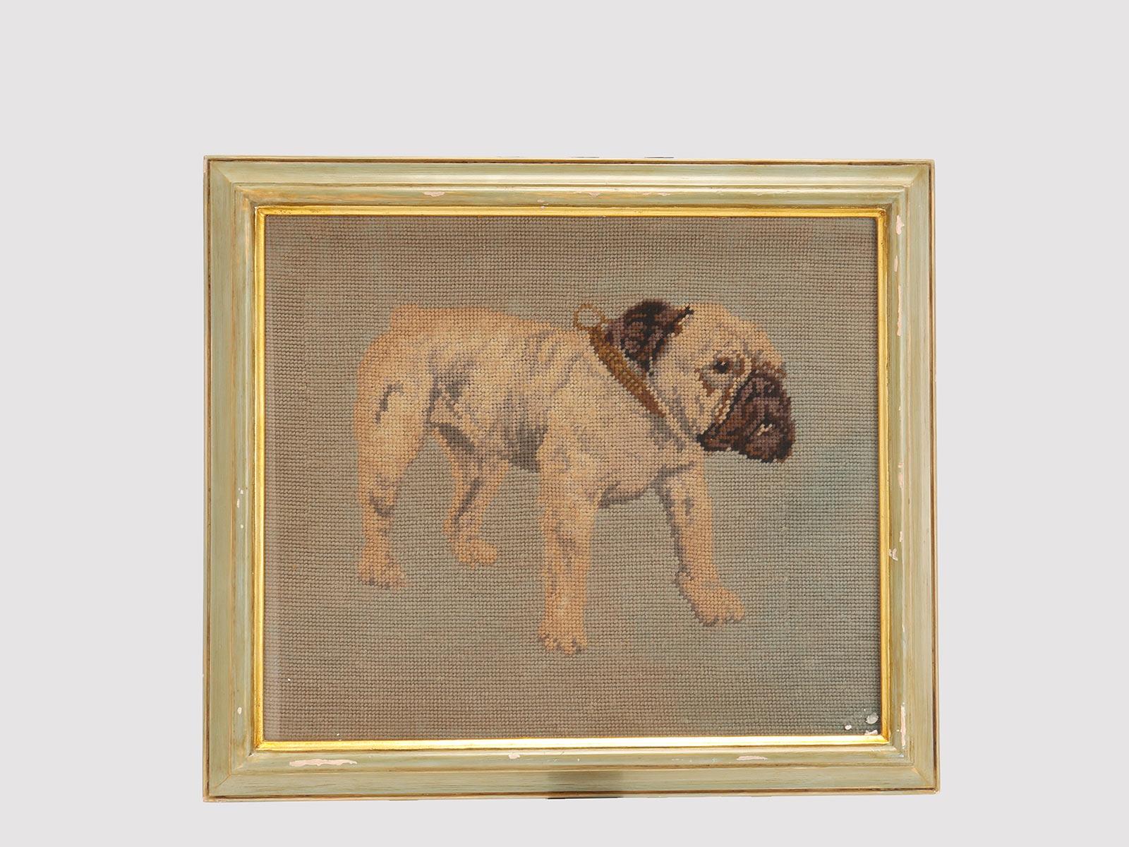 Broderie au petit point encadrée, représentant un chien bulldog anglais, avec collier, en position debout, portrait de trois-quarts. Le cadre est en bois peint et doré. Autriche vers 1880.