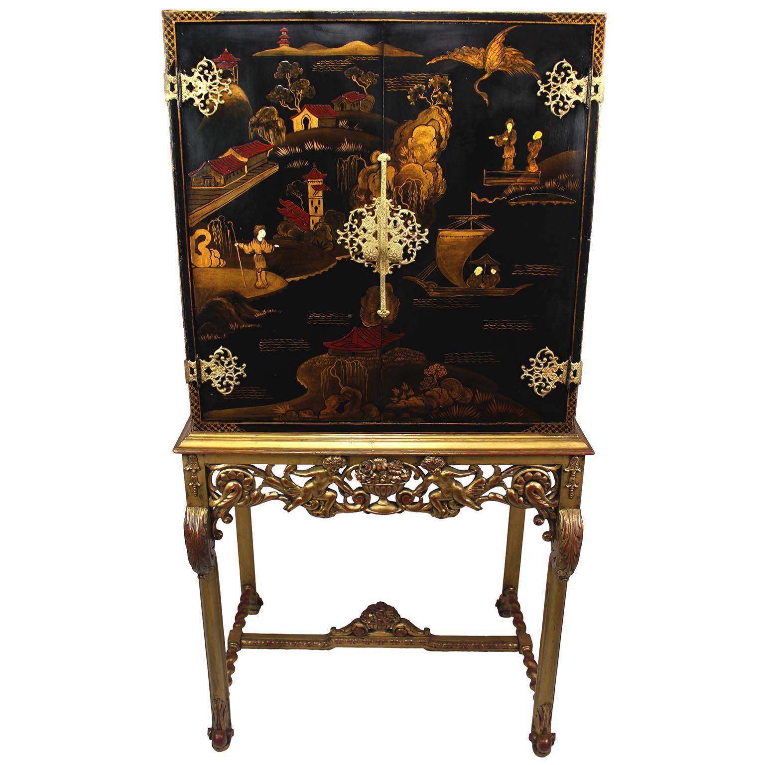 A Franco-English 19th/20th Century Chinoiserie Style Two-Door Cabinet on Stand, the black-laquered top with parcel-gilt and painted Chinese decorations of villages and coastal scenes, the inside with paneled dividers for file storage and a single