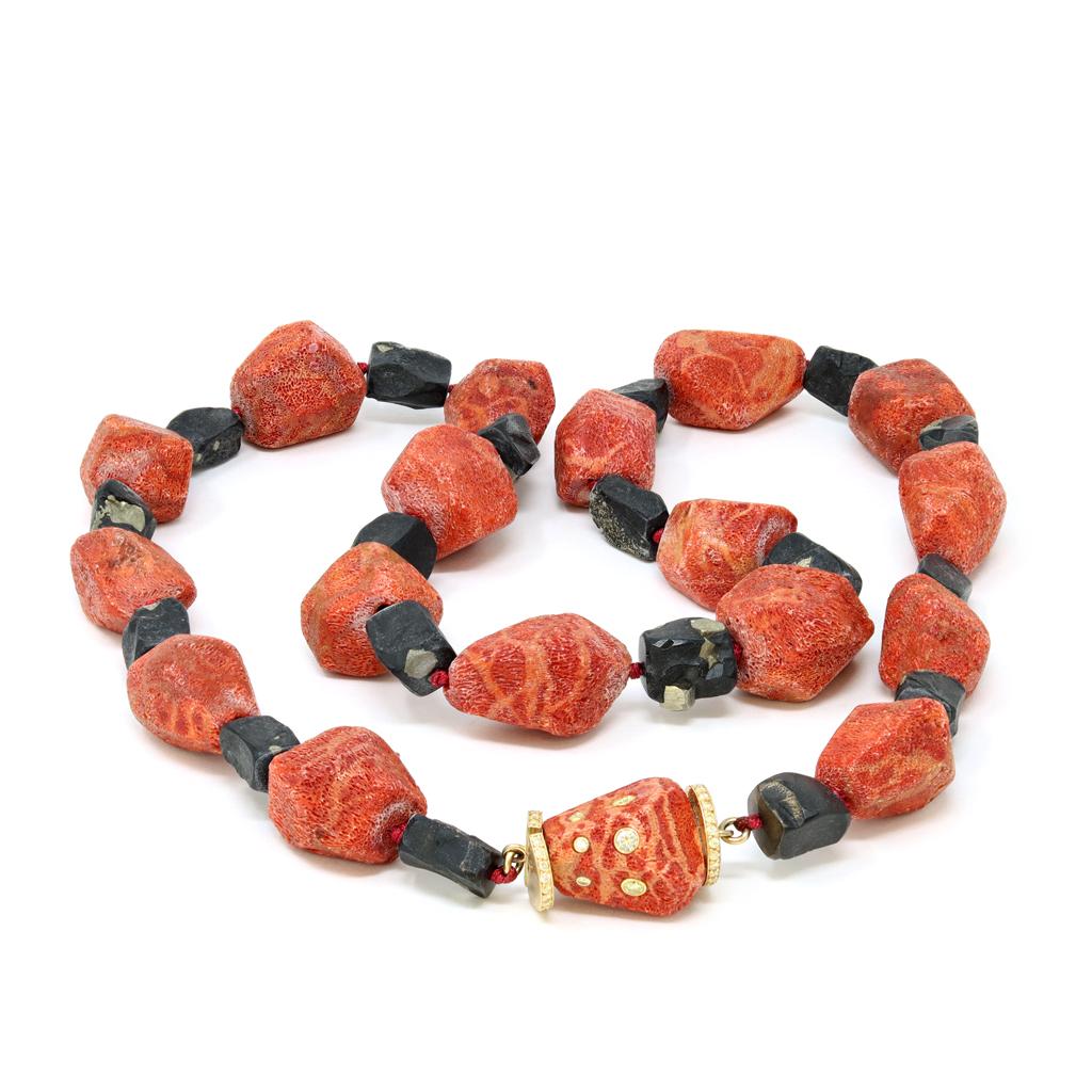 A one of a kind free form organic sponge coral and pyrite beads necklace. The necklace features a sequence of sponge coral and pyrite beads ending with a clasp composed of a diamond studded sponge coral bead. The clasp is 18 karat yellow gold. The