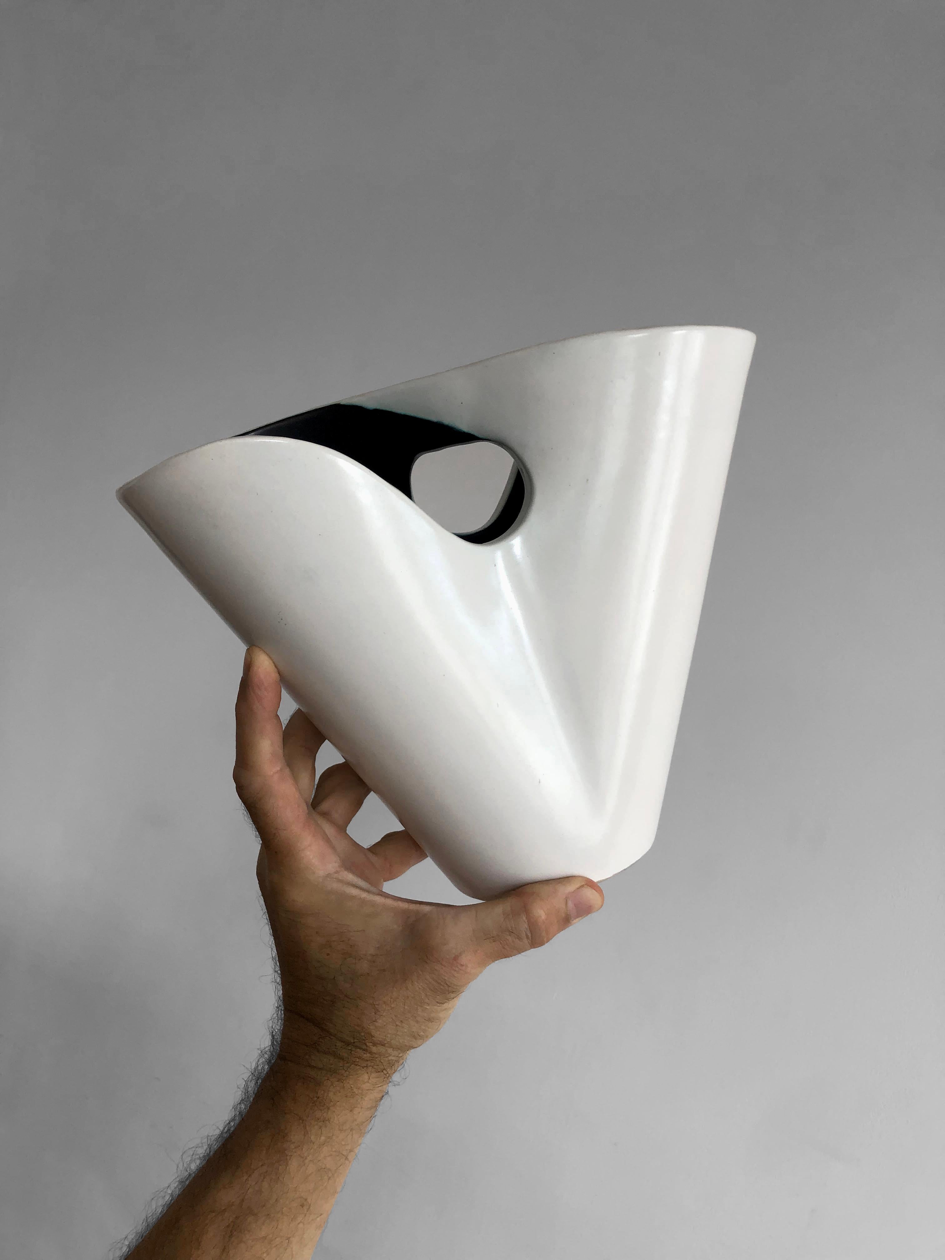 A very graphic openwork vase, Modernist, from Forme-Libre, sensual body in thick ceramic enameled white on the outside and black on the inside, creating a superb swirling effect around the openwork handle, incised Elchinger signature under the base,