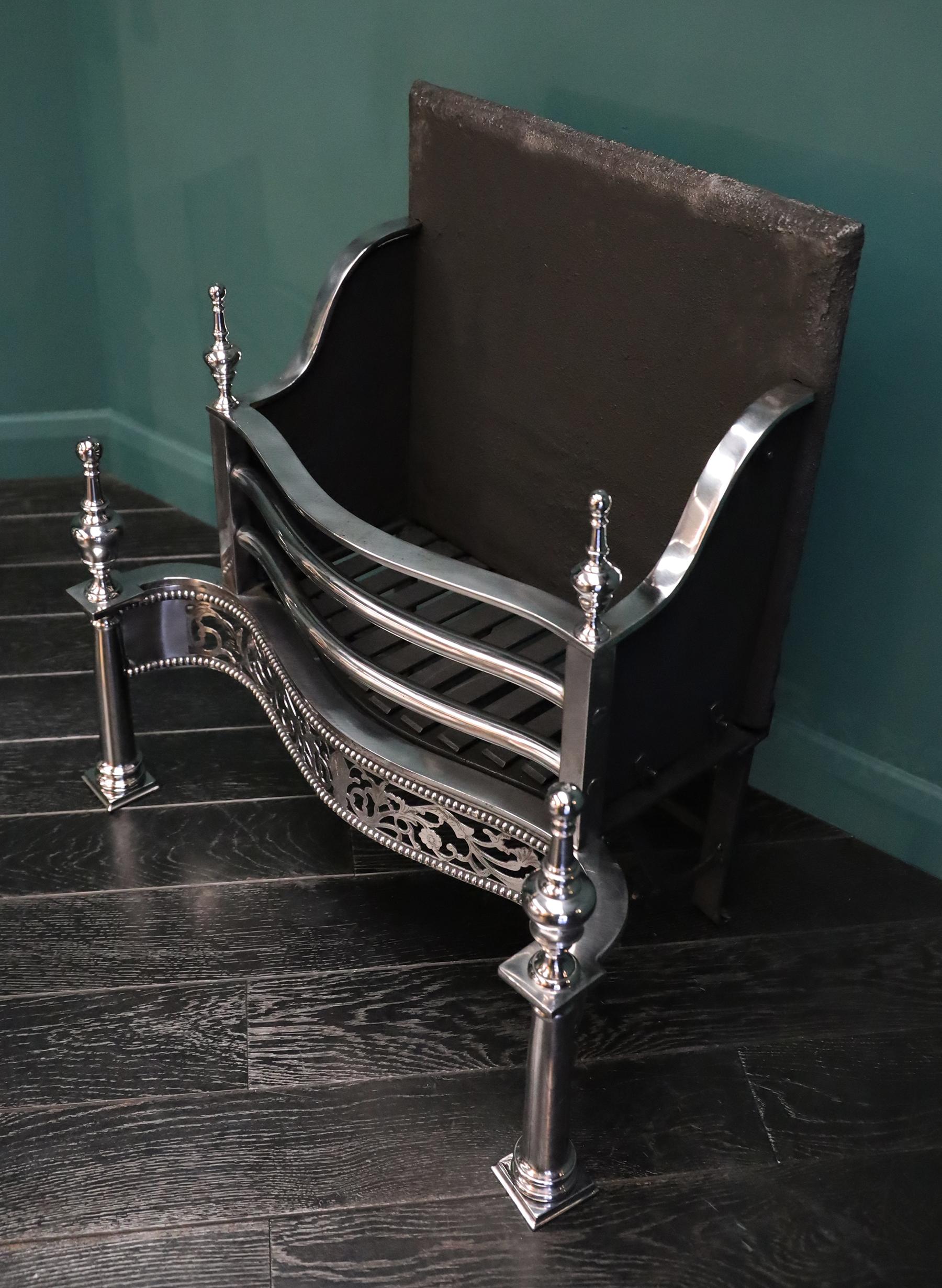 Ein freistehender Feuerrost aus poliertem Stahl in der georgianischen Form A. Der vergitterte Feuerkorb mit drei Feuerstäben über einem verzierten, durchbrochenen Bund steht auf zylinderförmigen Ständern mit stilisierten Urnenabschlüssen. Dieses