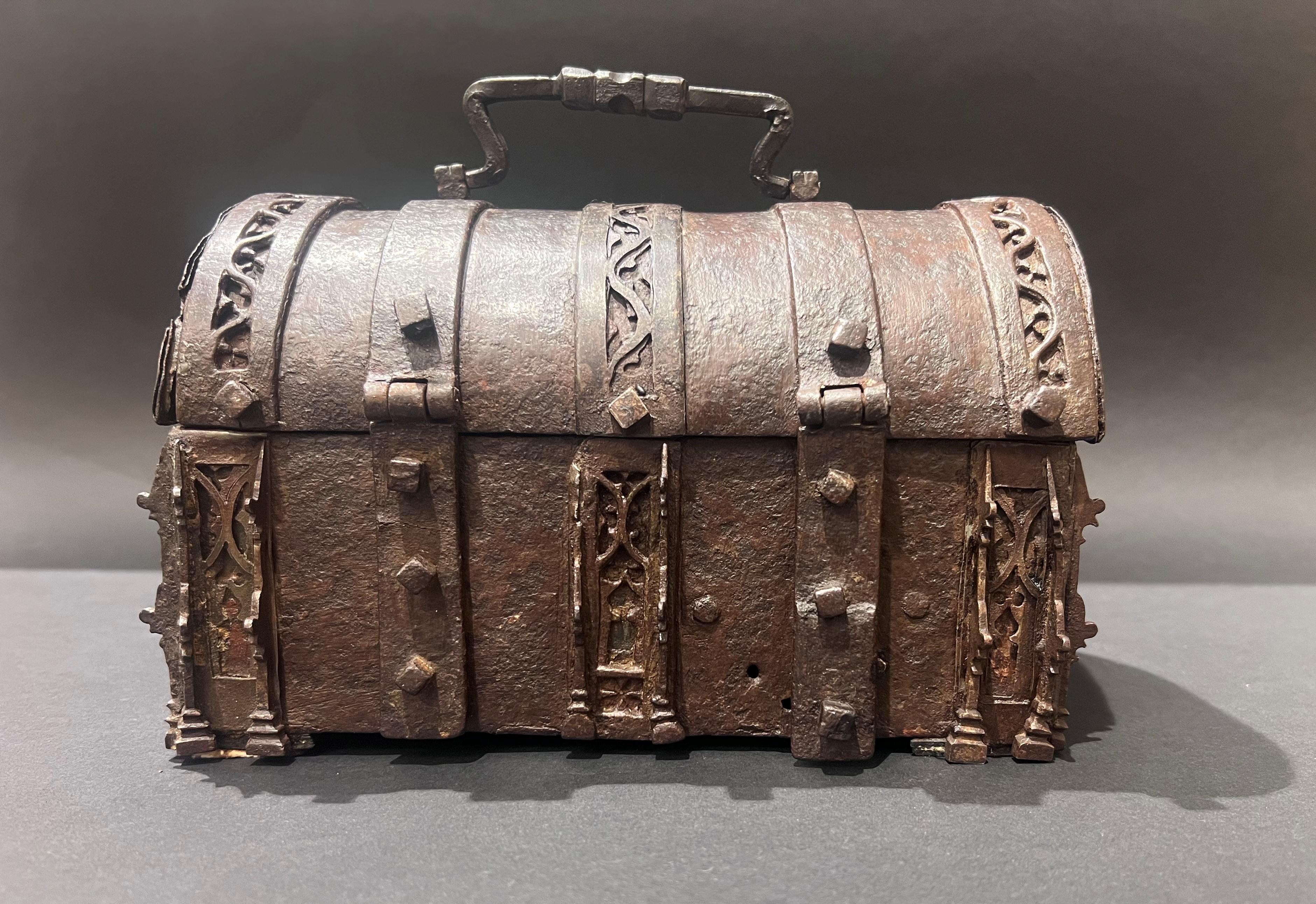 A French gothic iron casket
Dimensions: h. 18 cm, l. 23 cm, p. 14cm
15th century
France

Without key

A rare parallelepipedal box with a domed lid, it is decorated on all sides with frets with fenestrations flanked by pinnacles. Hinged on one side,