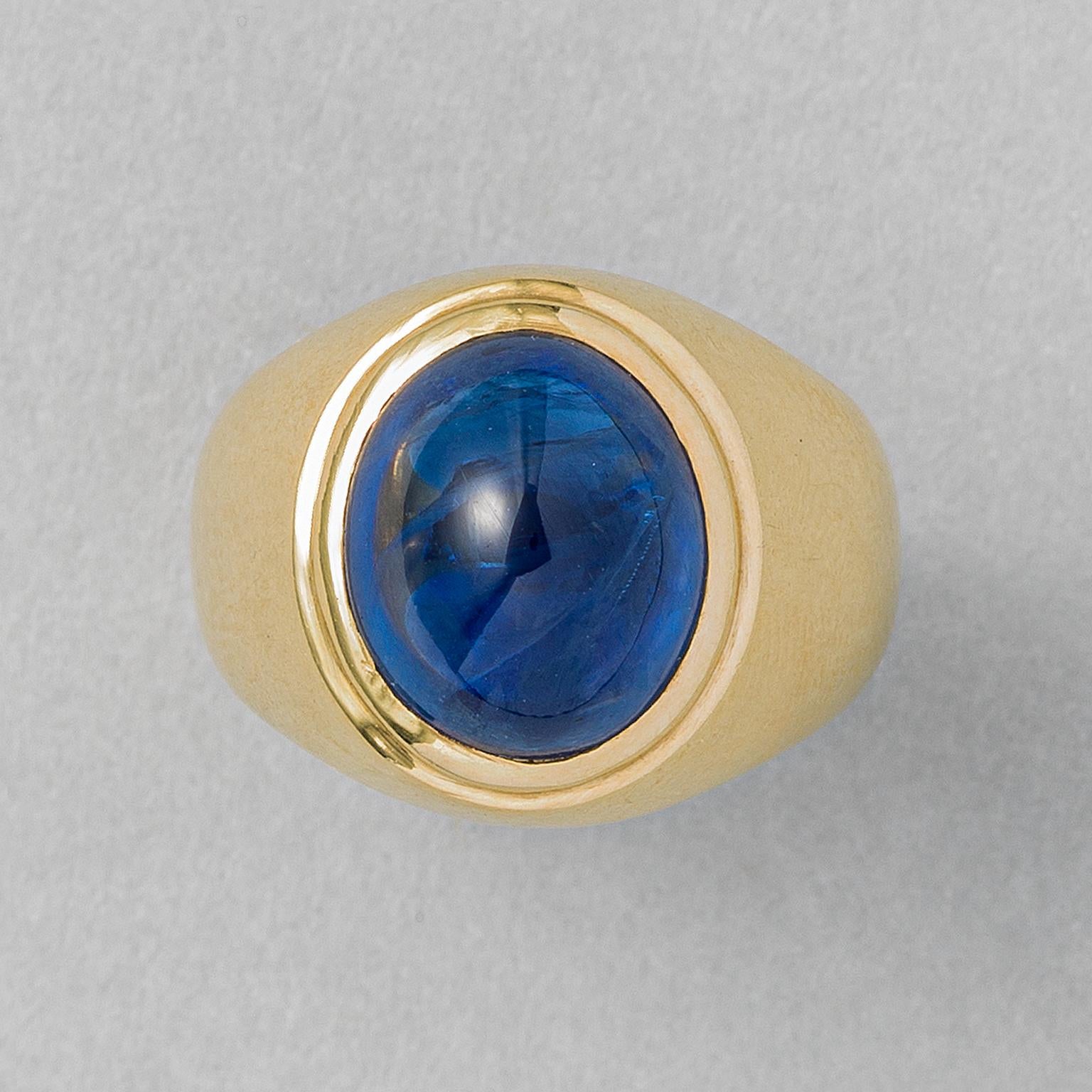 An 18 carat gold ring flush set with a high cabochon cut, slightly violetish blue natural heated sapphire from Sri Lanka (app. 9 carat, NEL certificate, E19324.) flush set with a double border, with French master mark and aigle. 

weight: 13.90