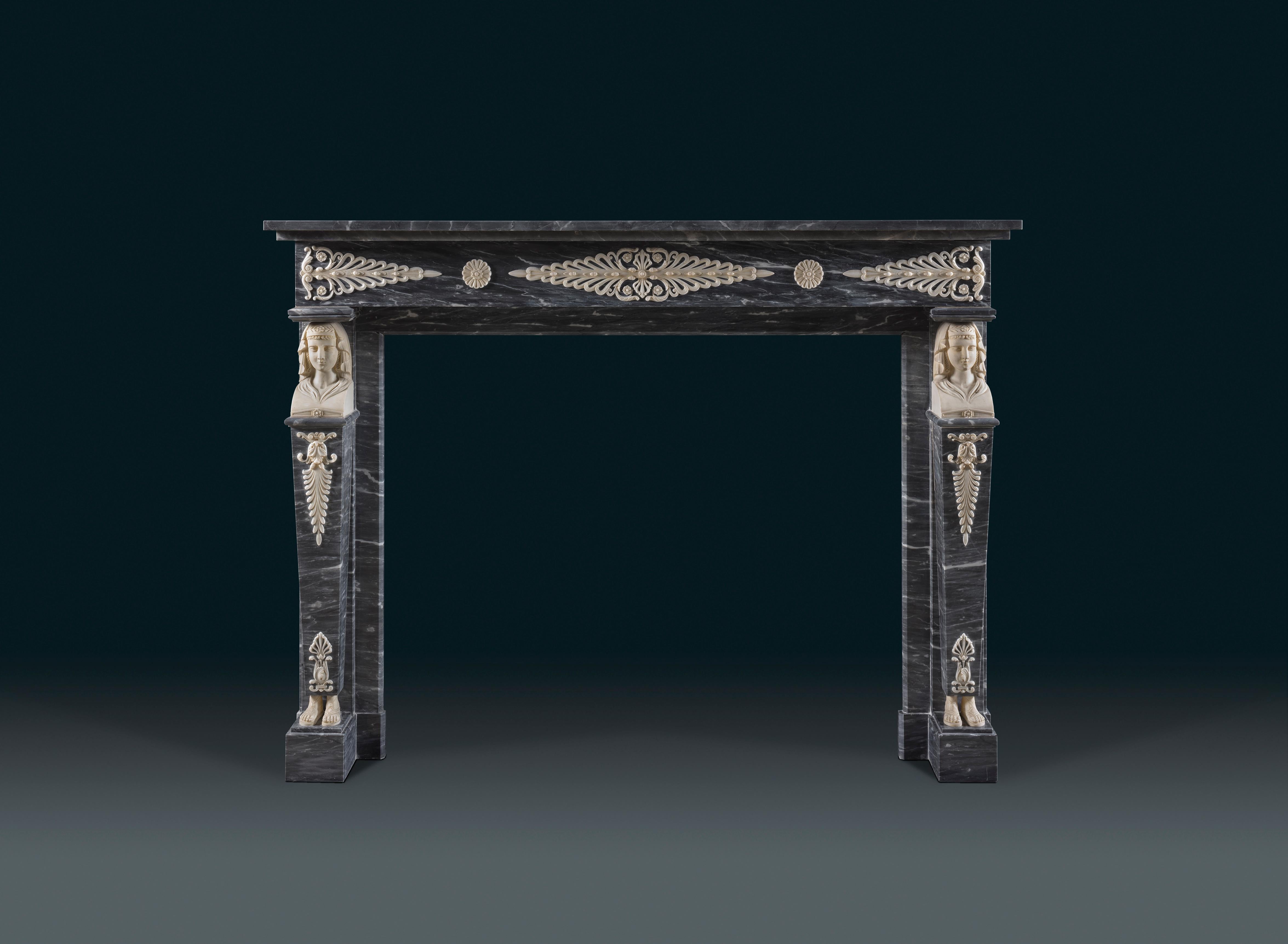 A French 1820’s chimneypiece carved in Bardiglio and statuary marble.
An early 19th century French fireplace in the Egyptian revival style, the simple rectangular shelf surmounts a frieze with palmettes and rosette paterae carved in white marble.