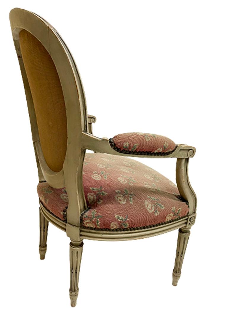 A French 18th century Louis XVI children's chair

A ca. 1775 French children's chair with an oval curved back with fluted legs and armrests. 
An antique embroidered seat, part of the armrests and back with rose motif. The fabric is partially