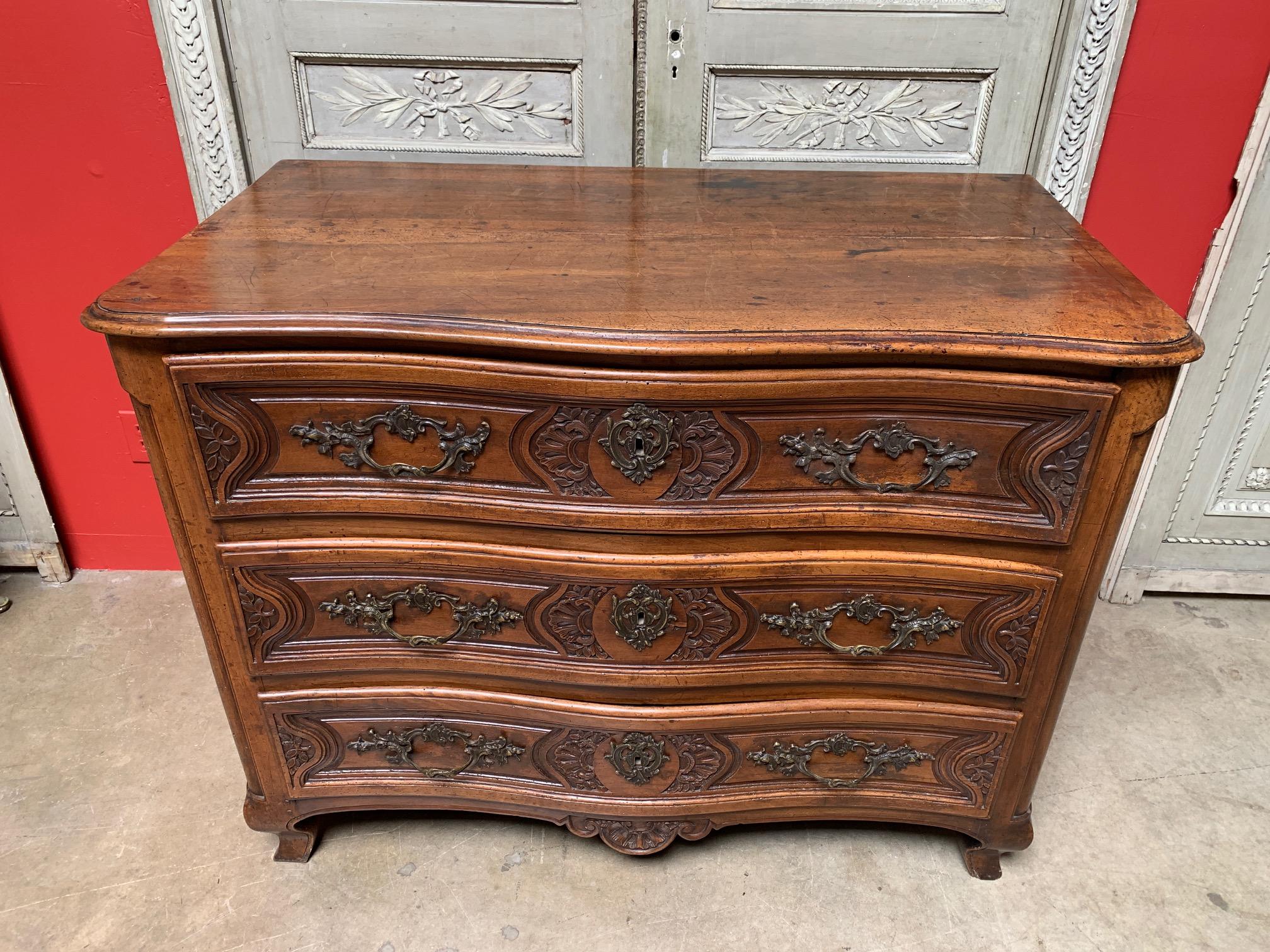 Exceptional 18th century Regence commode galbe´e (curved). Curved front with exquisite rocaille carvings, having three drawers and a shaped apron. Rests on short cabriole legs with sabot de biche. Beautiful bronze lock work, escutcheons and handles.