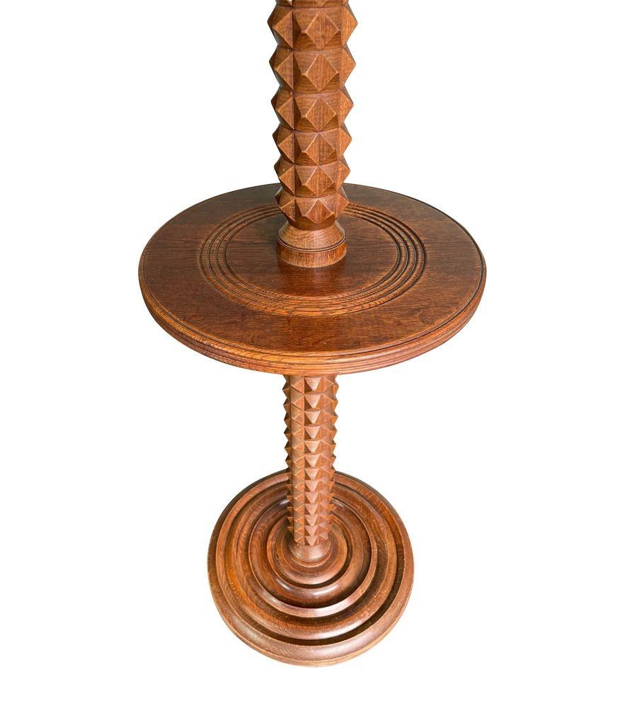 A French Art Deco, 1940s oak floor lamp attributed to Charles Dudouyt with unusual geometric detailing on the stem and interesting central, circular table addition. Re-wired with new brass fittings and new bespoke linen shade.