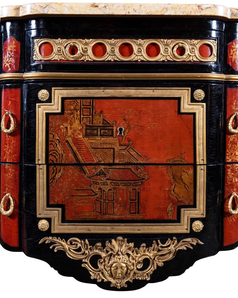 A French 1940s Transitional Style Red & Black Chinoiserie Commode

A French 1940s transitional style Chinoiserie lacquered and gilt bronze mounted breakfront commode, attributed to Maison Jansen, with sienna marble top, over a single drawer freize