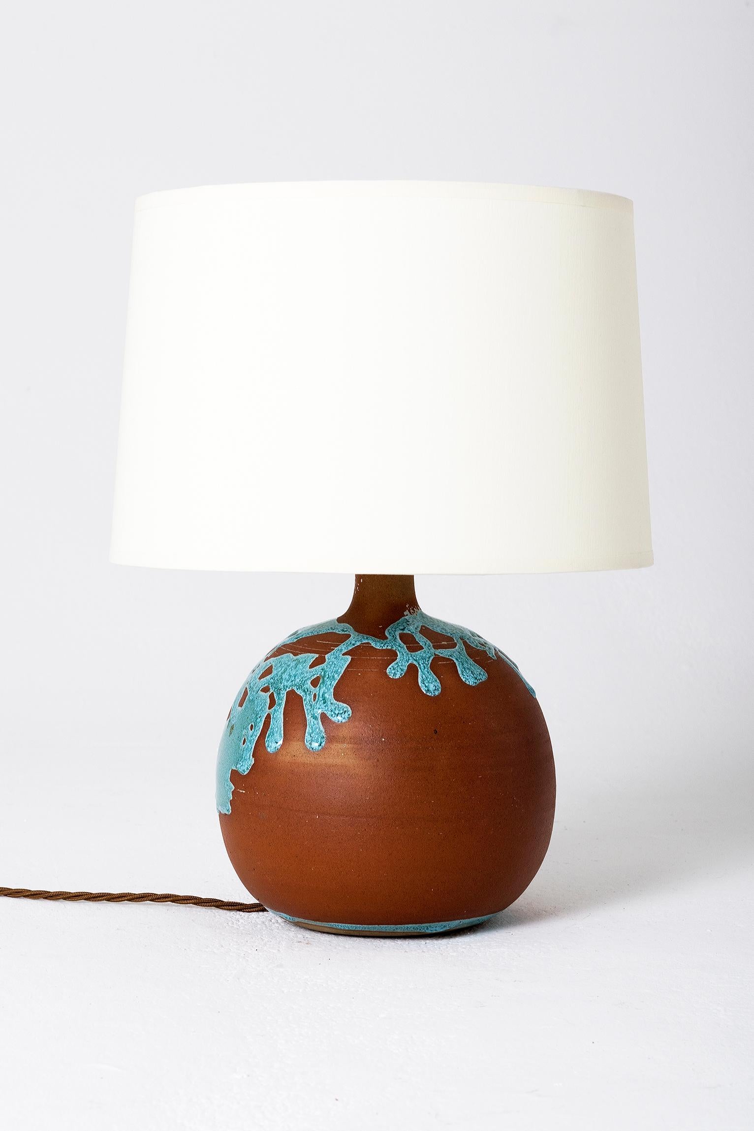 A terracotta and turquoise glaze table lamp
France, circa 1960
Measures: With the shade 39.5 cm high by 25 cm diameter
Lamp base only 22 cm high by 19 cm diameter.