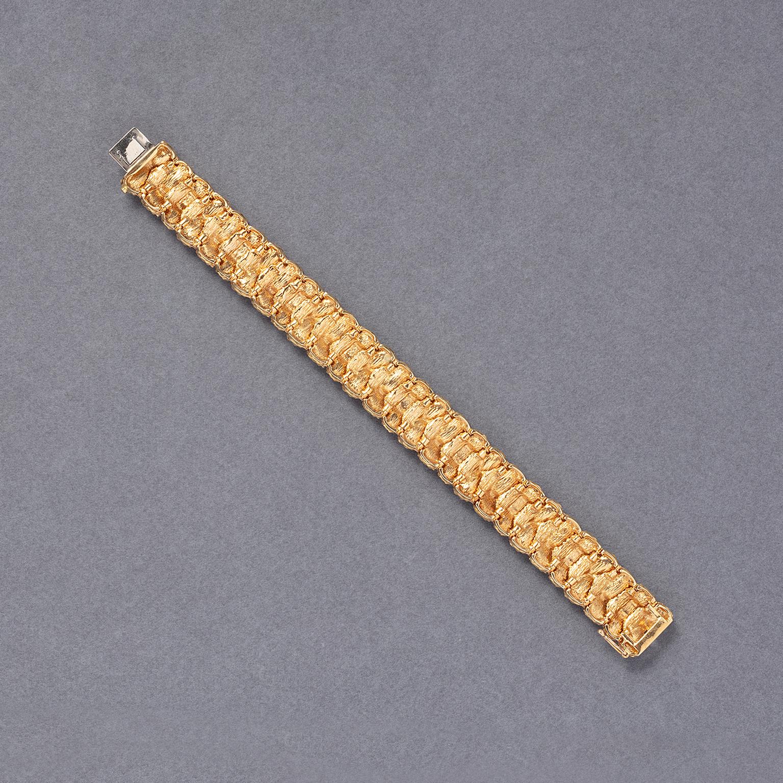 An 18-carat gold bracelet with links alternated with two or three ovals with striped concave elements, with a French master mark, France circa 1960.

weight: 49.8 g
length: 18.5 cm
width: 15 mm