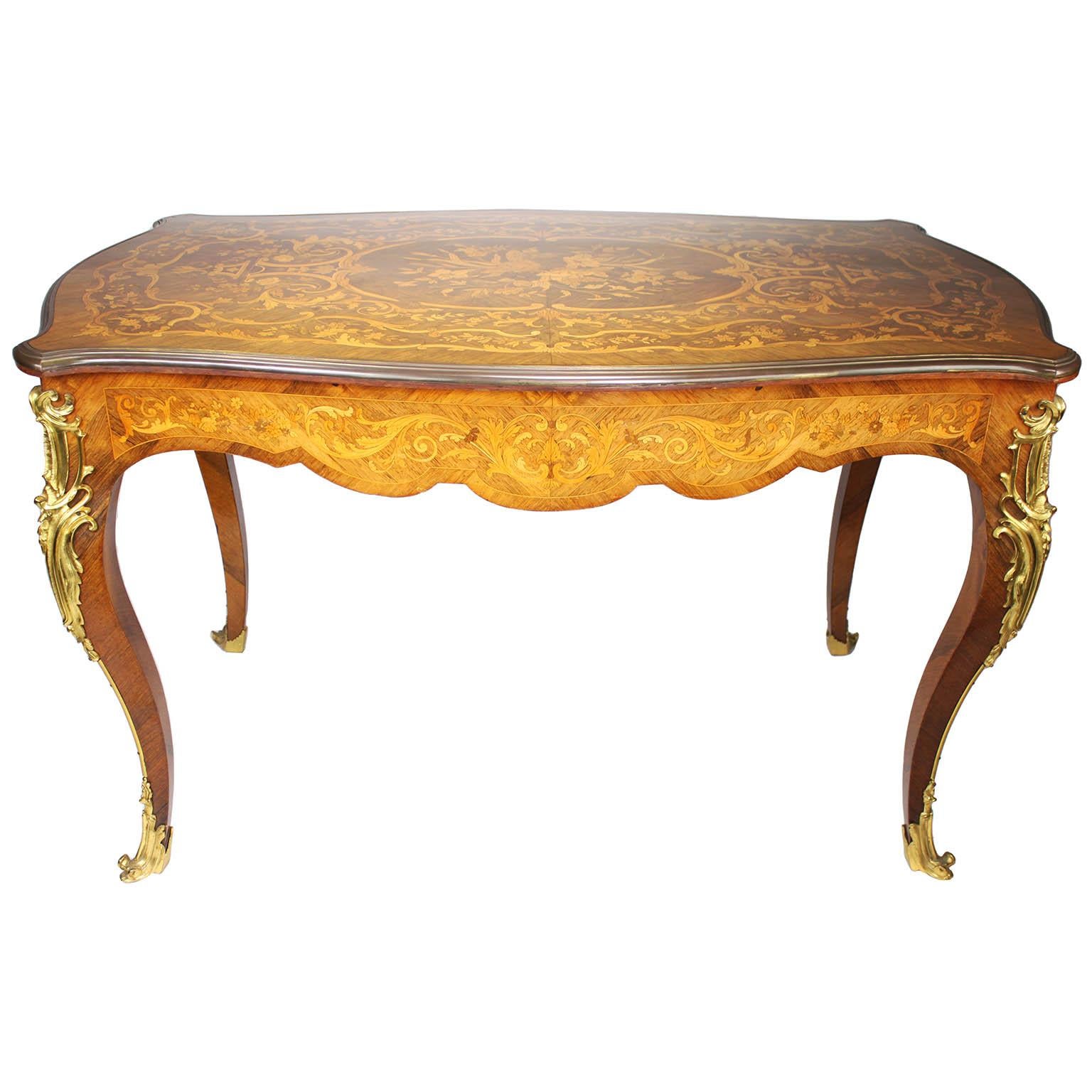 A Fine French 19th/20th Century Louis XV Style Tulipwood Marquetry and Gilt-Bronze Mounted Ladies Writing Table or Desk. The single drawer center table surmounted on each corner with ormolu mounts of leaves and acanthus, the top with an ornate