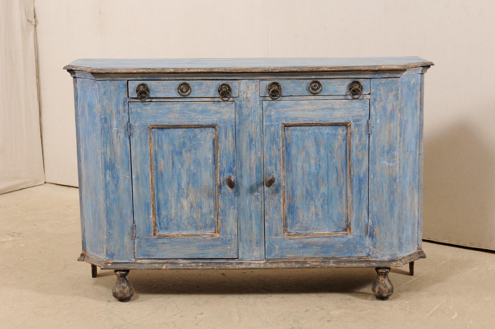 A French painted wood sideboard cabinet from the 19th century. This antique cabinet from France features a mostly rectangular top and case with canted sides, adding interest to it's shape, raised nicely upon bulb style wooden feet. The case houses a