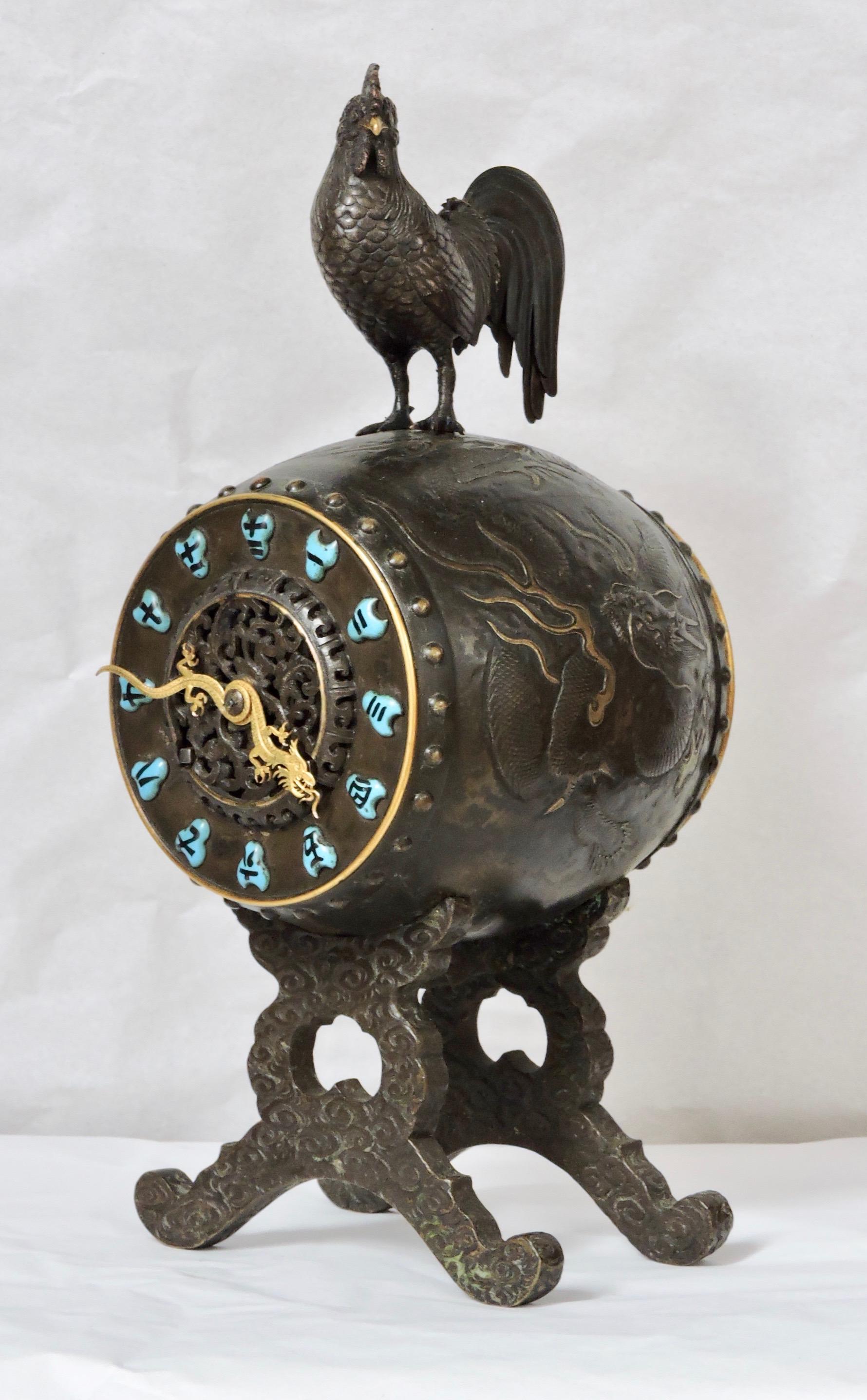 A very fine bronze brown and gilt patina French 19th century timepiece in the oriental Chinese taste.
In an Archaic style bell with molded relief dragons circling body, surmounted by a rooster.
The dial in turquoise blue porcelain with Chinese