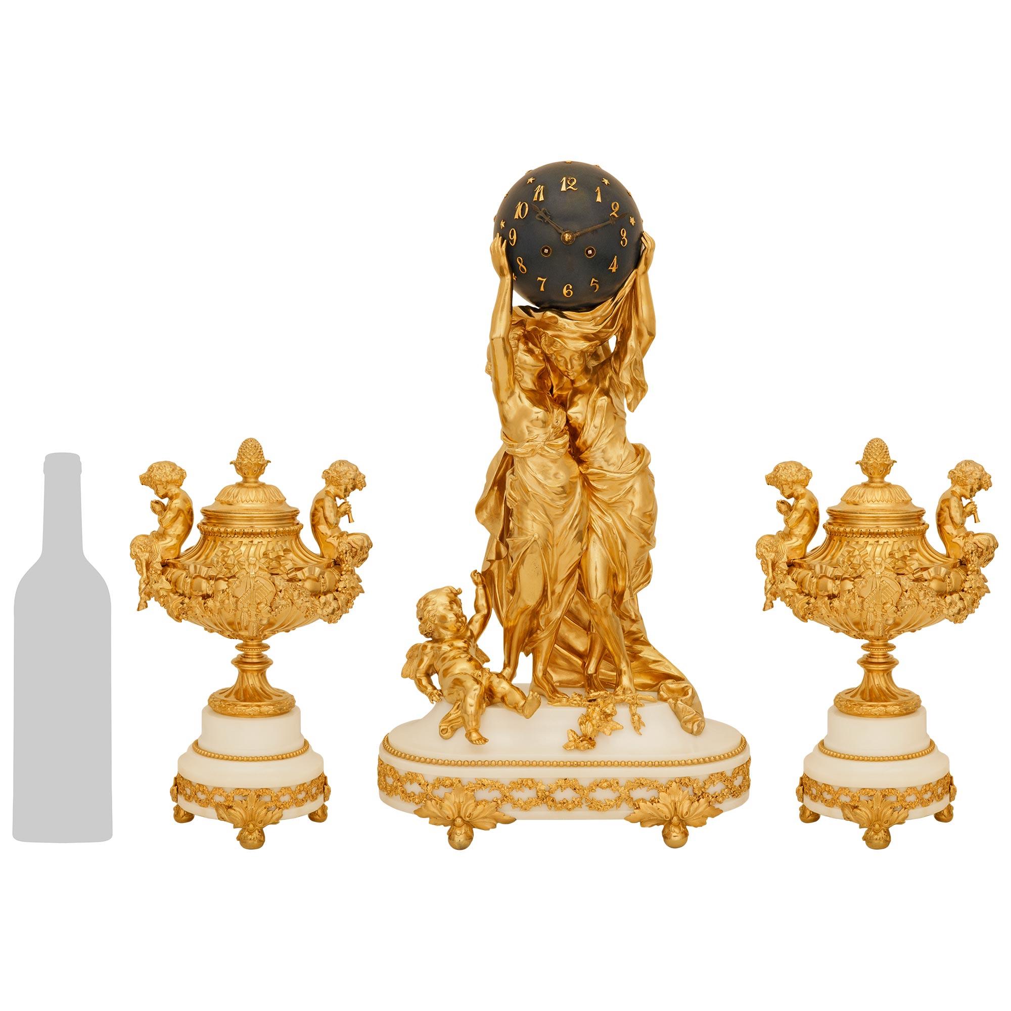 A sensational and high quality French 19th century Belle Epoque Period Louis XVI st. white Carrara marble and Ormolu clock garniture set. This stunning garniture set consists of a clock and a pair of lidded urns raised by Ormolu ball feet decorated
