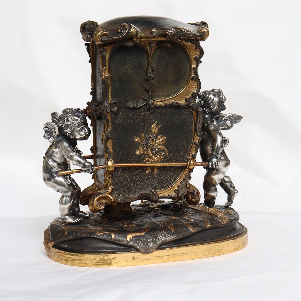 A French 19th Century Three patinas Bronze Jewelry Casket 
Designed with two silvered cherubs carrying a Sedan Chair in brown and gilt patina.
The top of the Sedan Chair opening revealing a jewelry casket.
Signed Auguste Moreau (1834-1917)
Circa