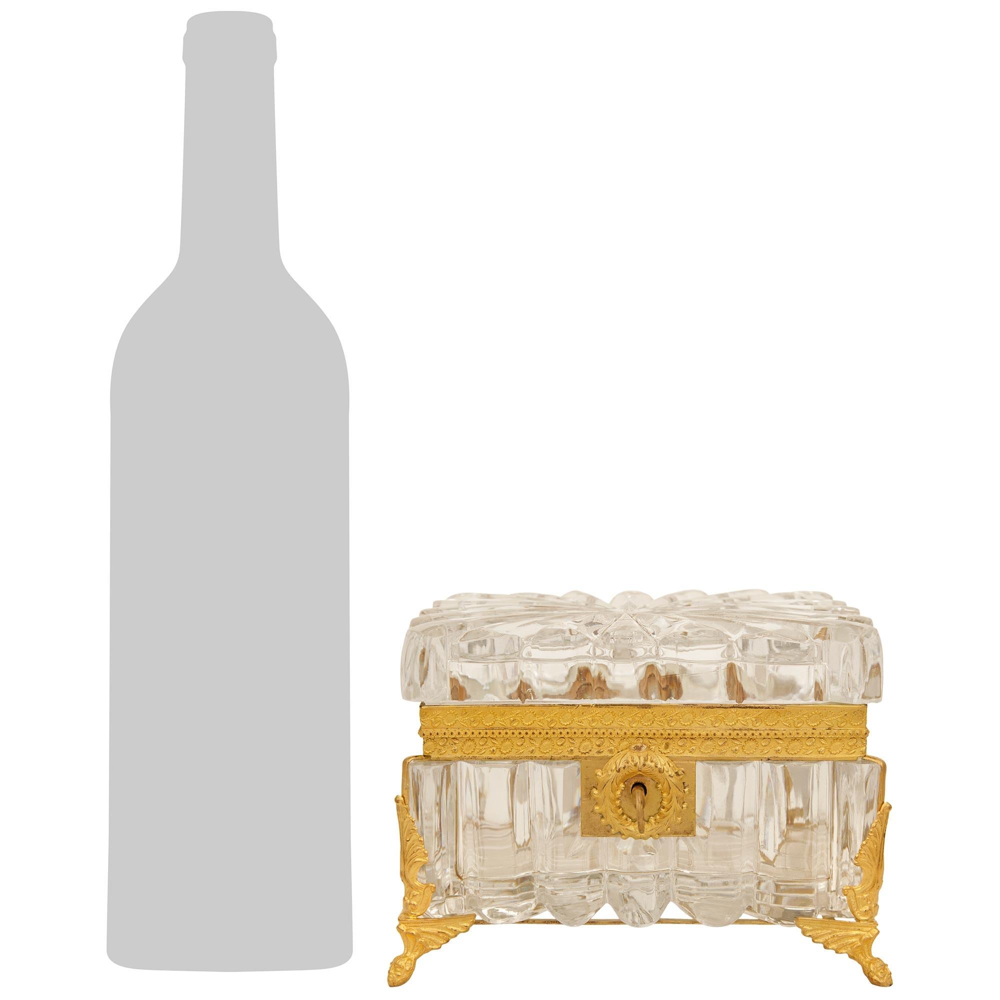 An elegant and high quality French 19th century Charles X Period Baccarat Crystal and Ormolu box. The stunning rectangular lidded Baccarat Crystal box is raised by four Ormolu supports with bottom masculine faces below wing like designs topped with
