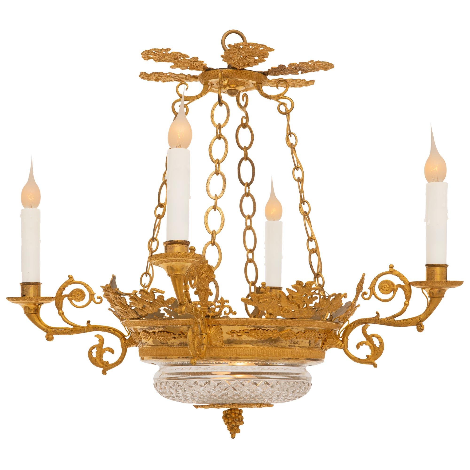 An attractive French 19th century Charles X period Ormolu and Crystal chandelier. The four arm chandelier has a bottom ormolu mount with designs of intertwined cornucopias filled with blossoming flowers and central finial. The mount above holds the
