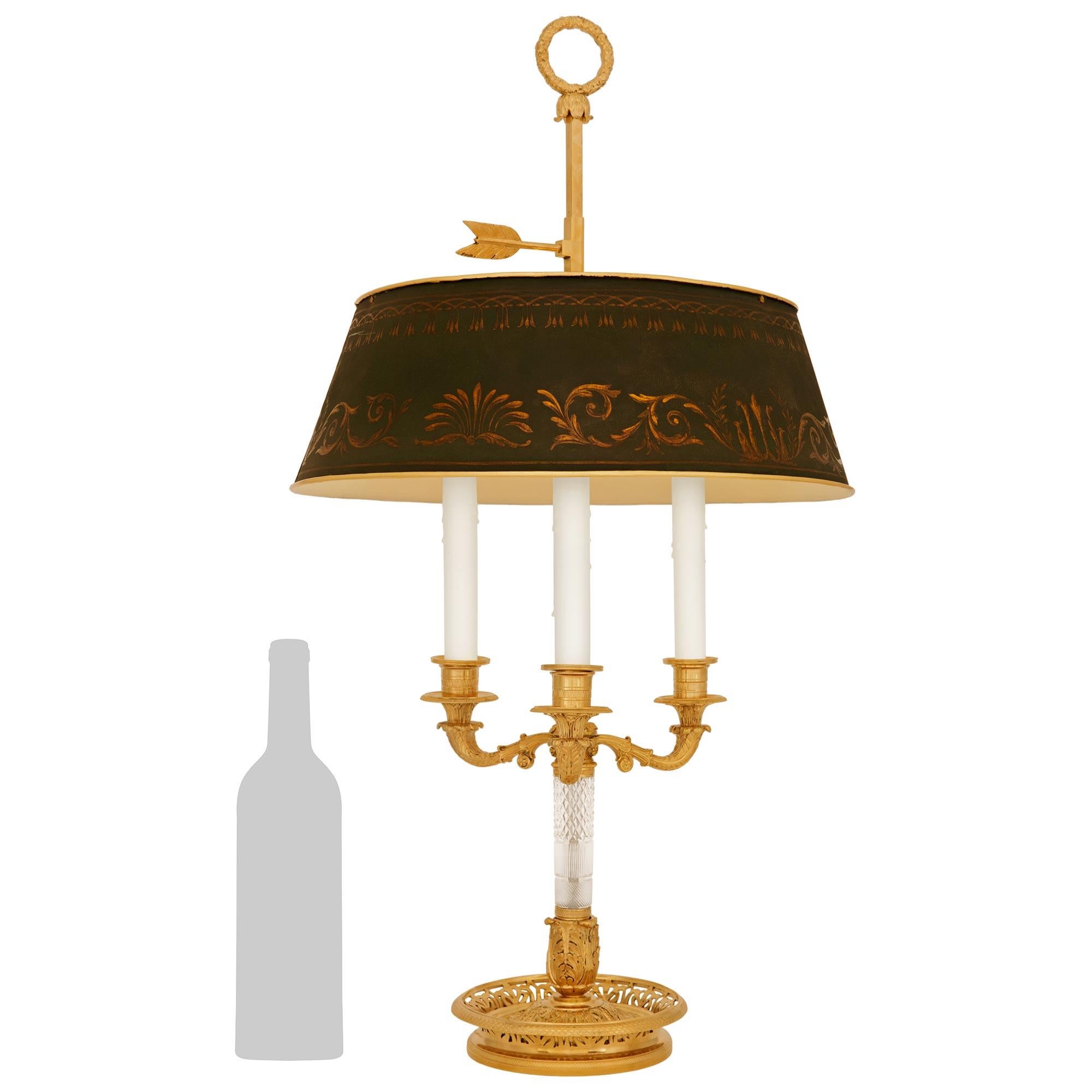 A elegant and high quality French 19th century Charles X Period Ormolu, Tole and Crystal bouillotte lamp. The charming lamp, with an adjustable shape, is raised by a circular pierced base with a bottom snakeskin designed band and top fish scale