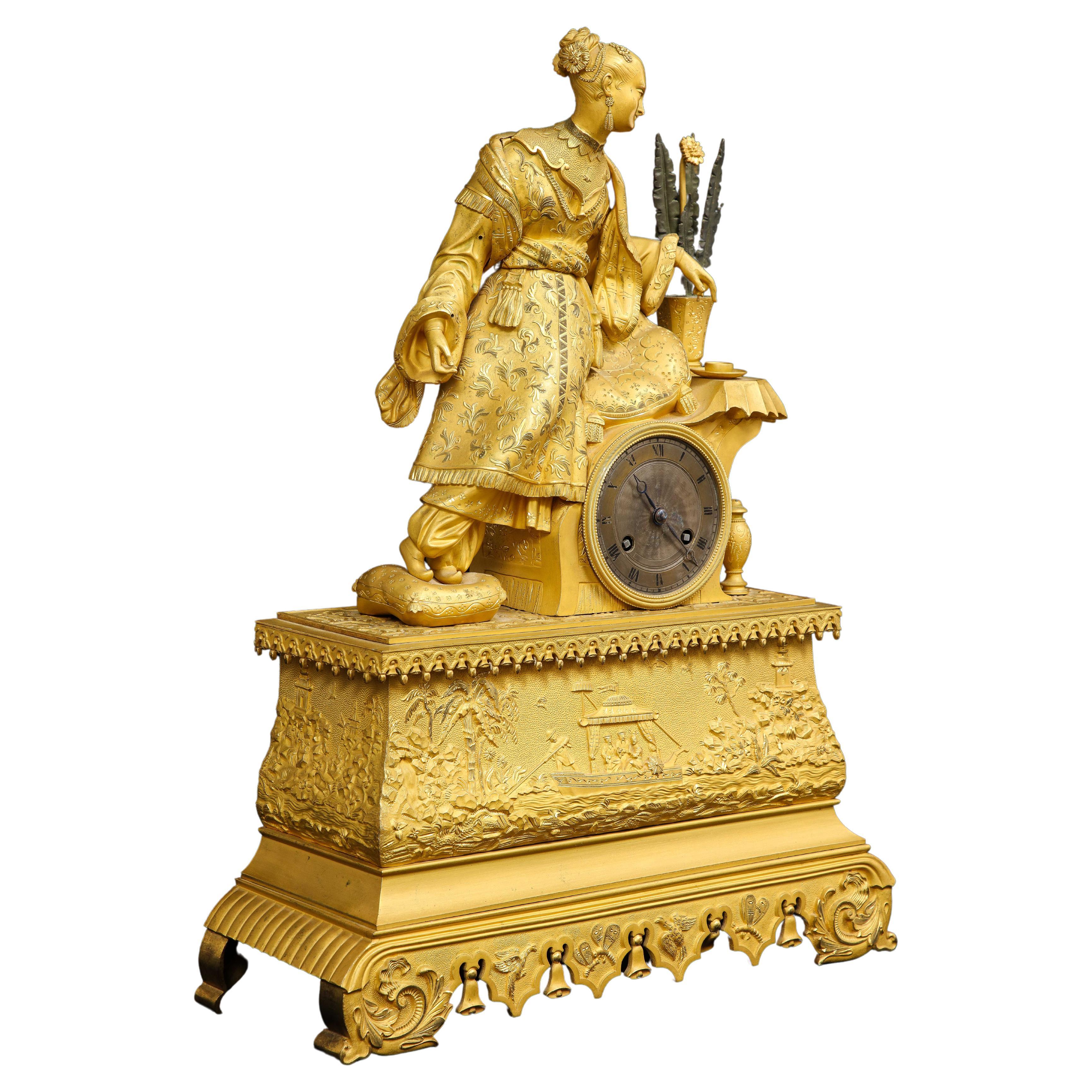Eine französische Dore-Bronze-Uhr im Chinoiserie-Stil des 19. Jahrhunderts mit einer auf einem Sitz ruhenden Frau. Dies ist ein wunderschönes Beispiel französischer Dore-Bronze-Handwerkskunst gemischt mit dem Chinoiserie-Stil. Die Uhr zeigt eine