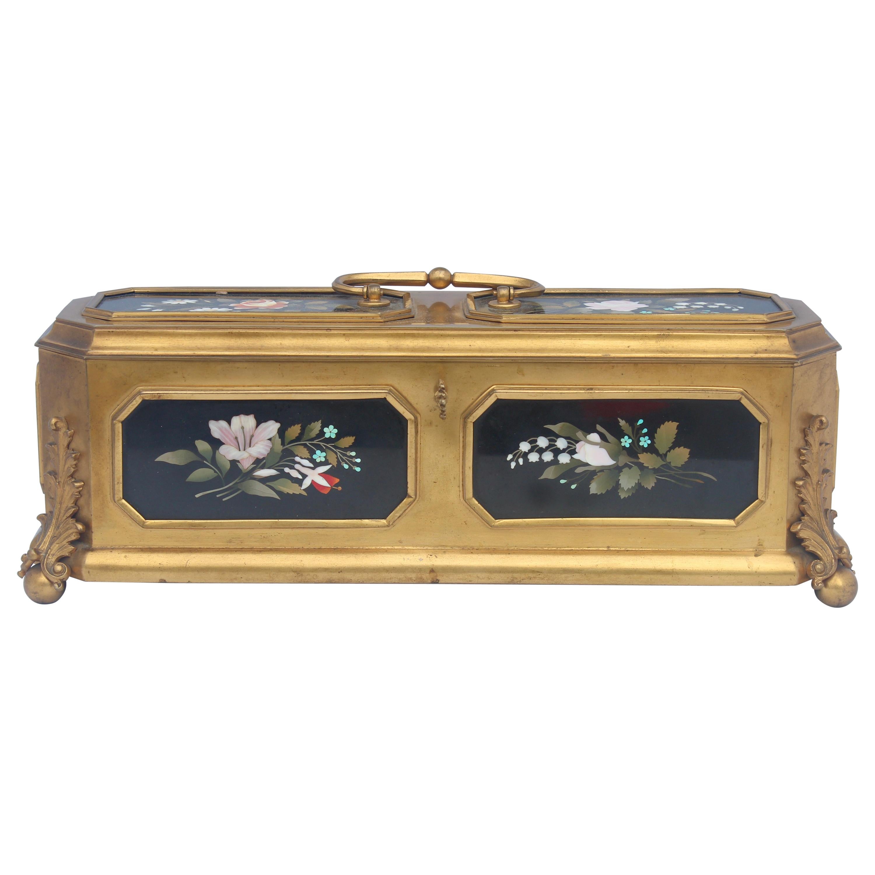 A French 19th century large ormolu jewelry casket
Decorated by Eight Flowers Design Polychromed Pietra Dura plaques, each of different design.
Original Capitonné silk inside
With an handle and its original key,
circa 1860

Attributed to Tahan