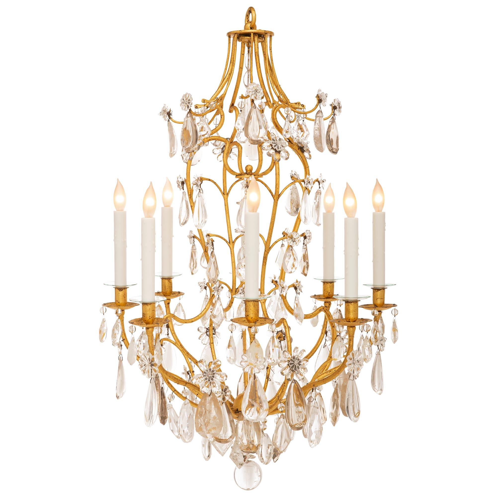 A very attractive French 19th century Gilt Iron, crystal and rock crystal chandelier. The eight arm chandelier is centered by a most decorative bottom crystal ball below the eight gilt iron arms adorned with lovely teardrop, pear shaped, cut, and